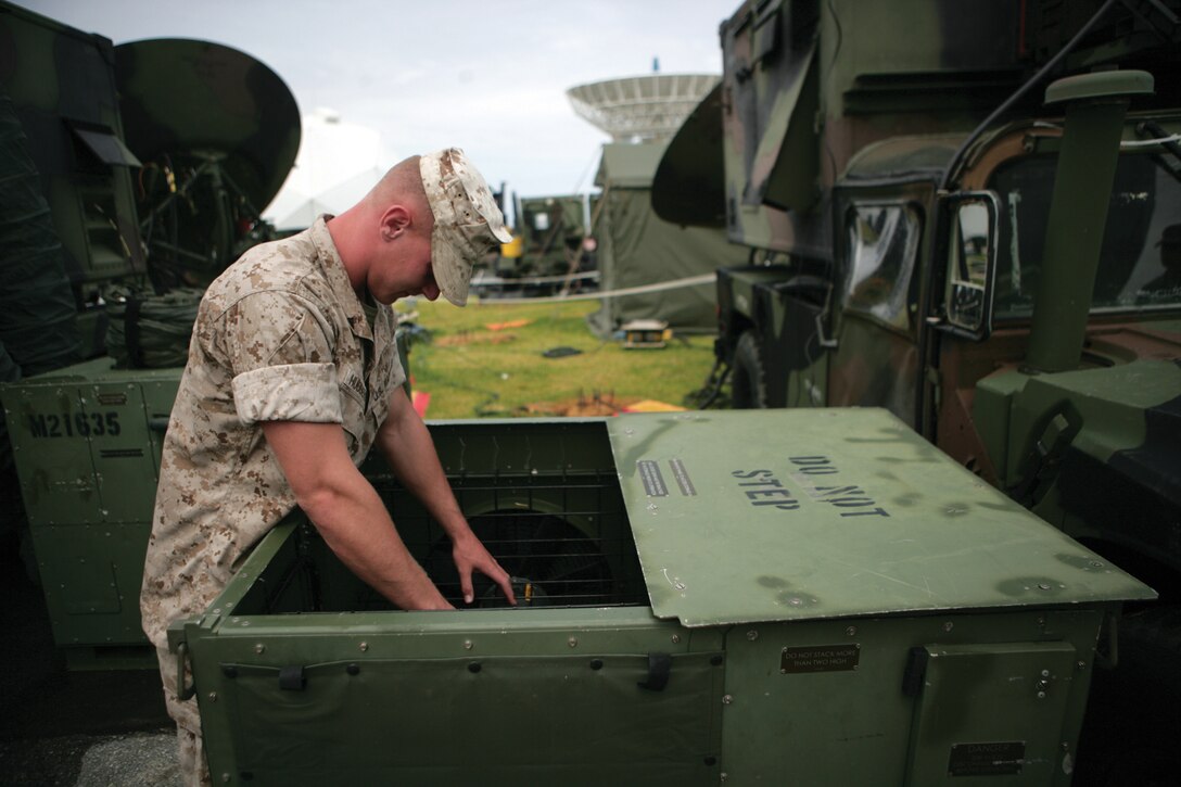 Pfc. Russell Johnston, satellite communications operator with 7th Communication Battalion, III Marine Expeditionary Force Headquarters Group, III MEF, makes sure an electronic control unit is cooling equipment at a steady rate July 22.