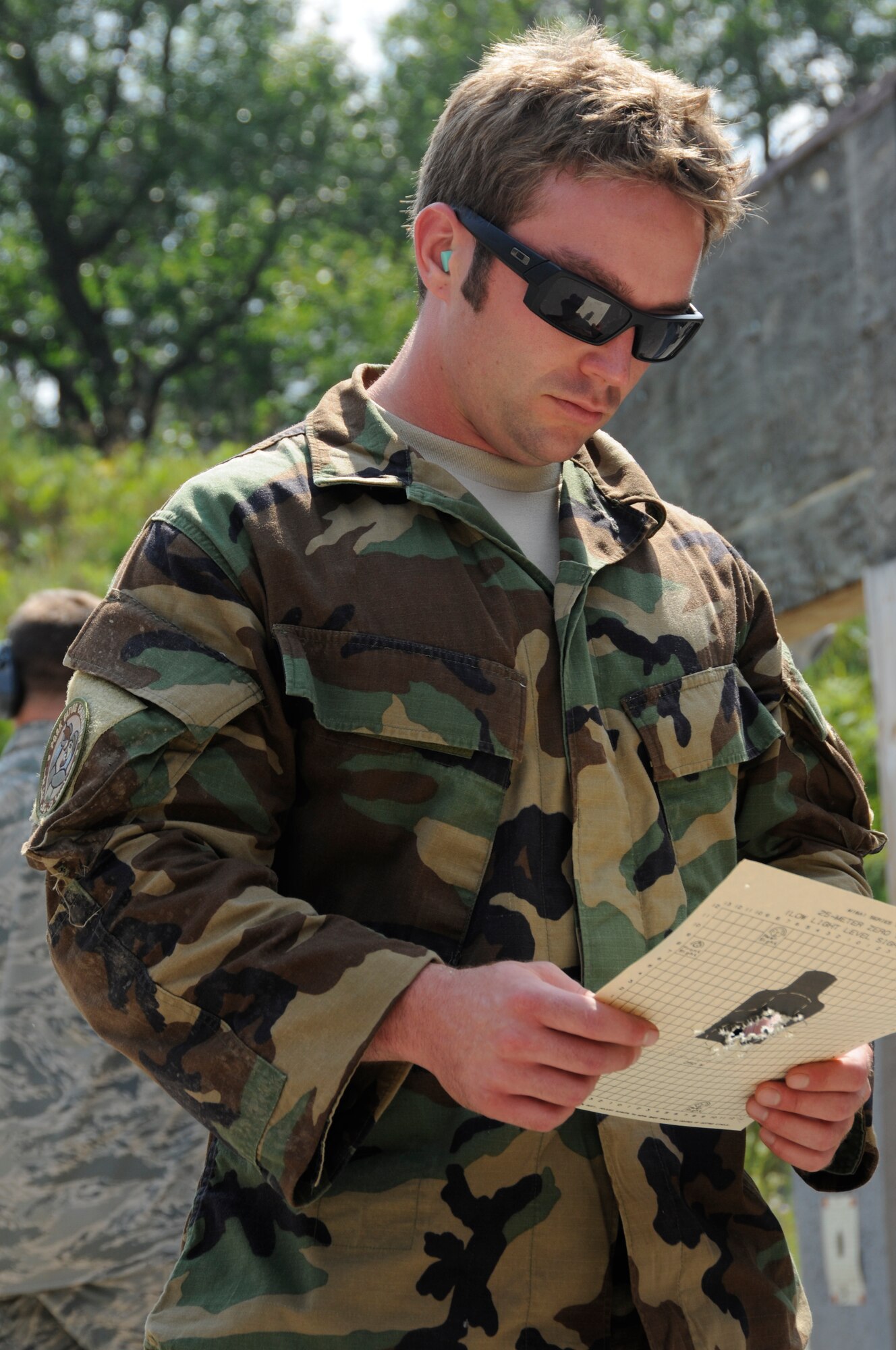 Staff Sgt. Richard Fisher from Selfridge Air National Guard Base, 107th Weather Flight, looks at the target sheet he used during a pre-qualification run with the M-4 rifle during the annual Gray Wolverine training exercise held at Combat Readiness Training Center Alpena, Mich., July 19, 2011. Fisher annually qualifies with the M-4 rifle at the Gray Wolverine training camp.  (U.S. Air Force photo by TSgt David Kujawa)