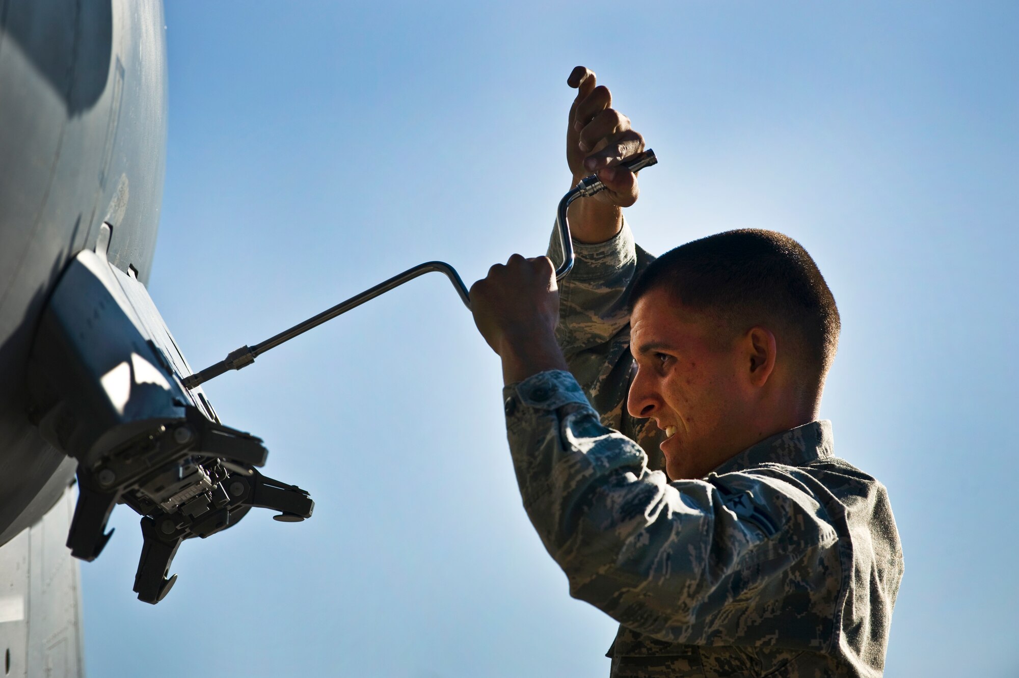 U.S. Air Force Airman 1st Class Earl Condra, 757th Aircraft Maintenance Squadron aircraft armament systems apprentice, prepares a F-15 Eagle for ordnance mounting during a weapons load crew competition July 22, 2011, at Nellis Air Force Base, Nev.  Weapons load crew competitions are conducted quarterly to keep Airmen sharp and recognize superior performers. Teams are evaluated for use of the checklist, safety, and overall speed. (U.S. Air Force photo by Airman 1st Class George Goslin/Released)