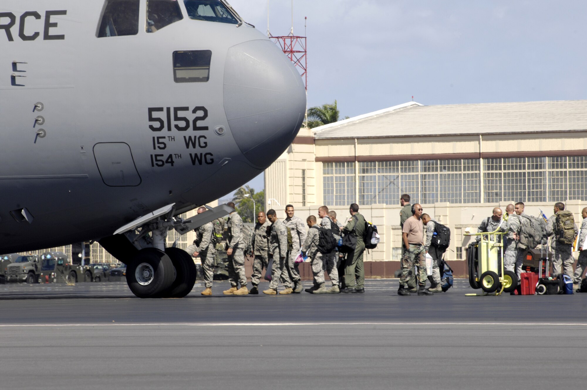 Members of the Team Hickam Rodeo 2011 contingent load a C-17 Globemaster III July 22. high-fives some other Wing Airmen July 22. The team will travel to Joint Base Lewis-McChord, Wash., for Air Mobility Rodeo 2011. This competition focuses on improving worldwide air mobility forces' professional core abilities. (U.S. Air Force Photo/David D. Underwood, Jr.)