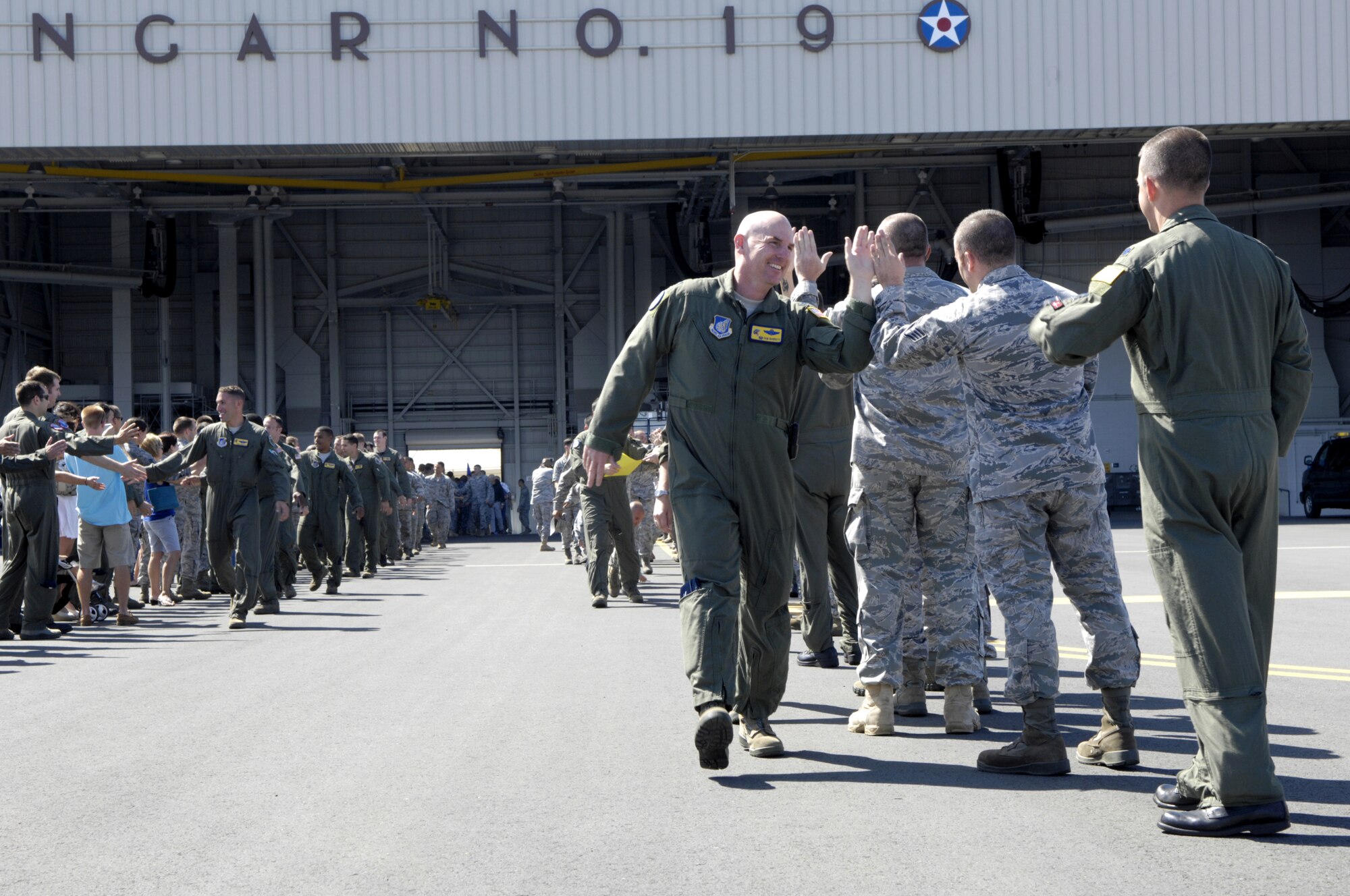 Col. Sam Barrett, 15th Wing commander, high-fives some other Wing Airmen July 22 as he departs Joint Base Pearl Harbor-Hickam, Hawaii. Barrett and the Team Hickam Rodeo 2011 Team will travel to Joint Base Lewis-McChord, Wash., for Air Mobility Rodeo 2011. This competition focuses on improving worldwide air mobility forces' professional core abilities. (U.S. Air Force Photo/David D. Underwood, Jr.)