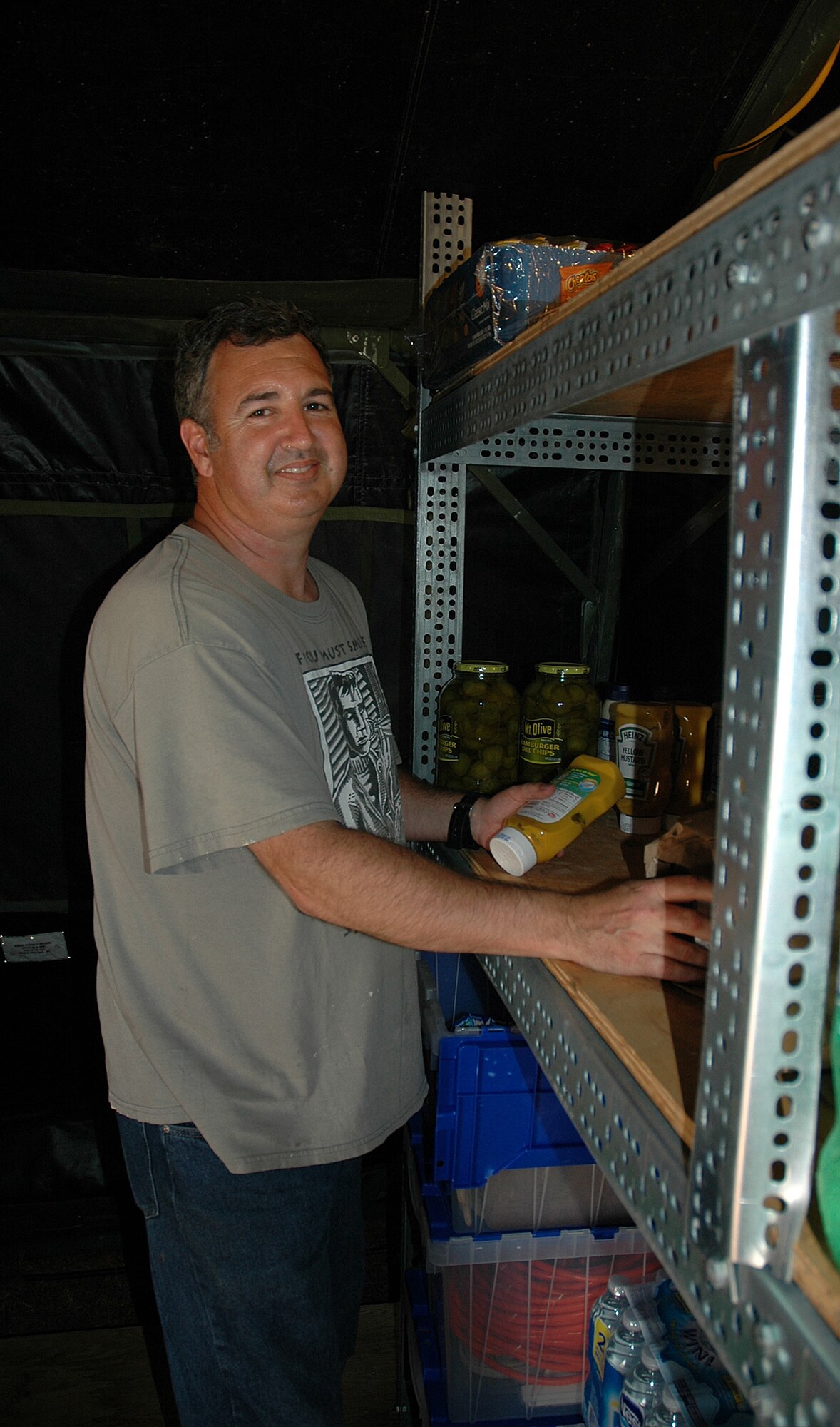Lt. Col. Lee Brady, 728th Airlift Squadron, stocks the shelves at the 446th Airlift Wing's tent at Rainier Ranch in preparation for feeding visitors during Air Mobility Rodeo, July 24-29 at McChord Field, Wash. (U.S. Air Force photo by Sandra Pishner)