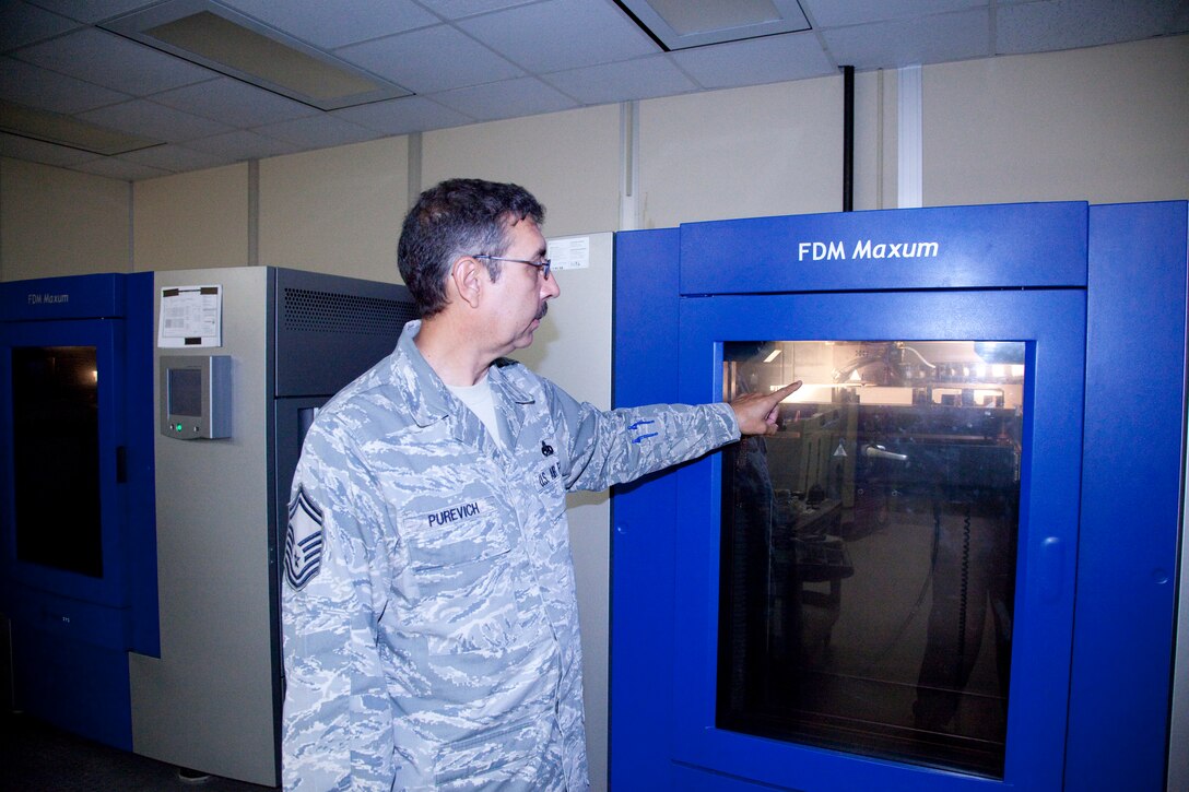 Senior Master Sgt. Walter Purevich, 982nd Maintenance Squadron flight chief, demonstrates the 3D layer process from start to finish July 22 at the 982 MSX facility. The 3D Fused Deposition Modeler (FDM) creates 3D solid models directly from 3D CAD files, or similar software, using polycarbonate, ABS plastic to build strong and durable, fully functional prototypes within hours. This process reduces the cost of materials through use of ABS plastic and reduction of wasted alloys. (U.S. Air Force photo/Danny Webb)