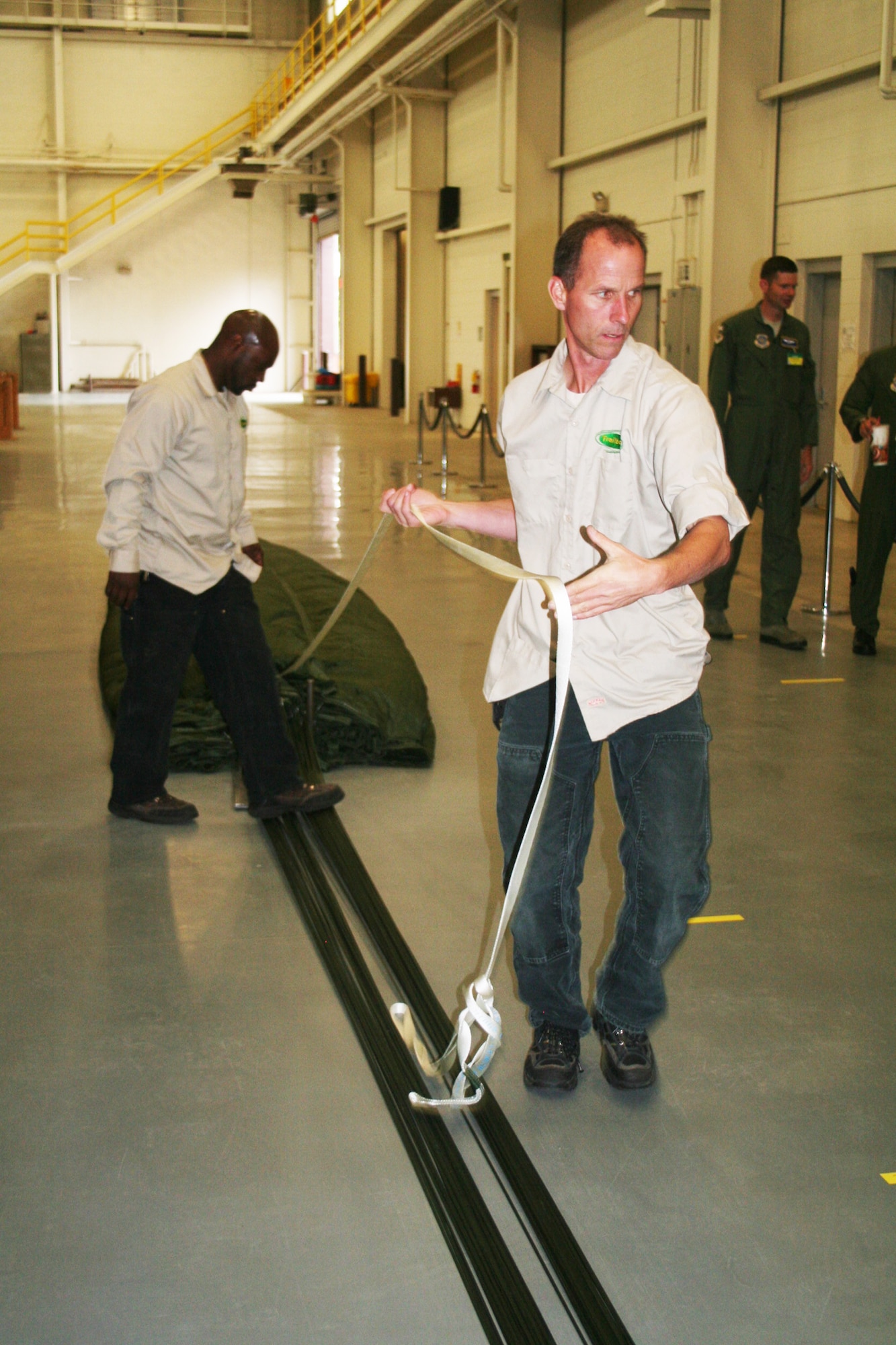 Romereo Scruggs and Jay Boison, parachute riggers at the 62nd Aerial Port Squadron aerial delivery facility, prepares a parachute for an airdrop bundle during operations at the facility July 21, 2011, at Joint Base Lewis-McChord, Wash. Scruggs and Boison, who work for contractor Trailboss, Inc., is one of eight people who operate the facility and prepare airdrop training bundles for the 62nd Airlift Wing's mission. (U.S. Air Force Photo/Master Sgt. Scott T. Sturkol)