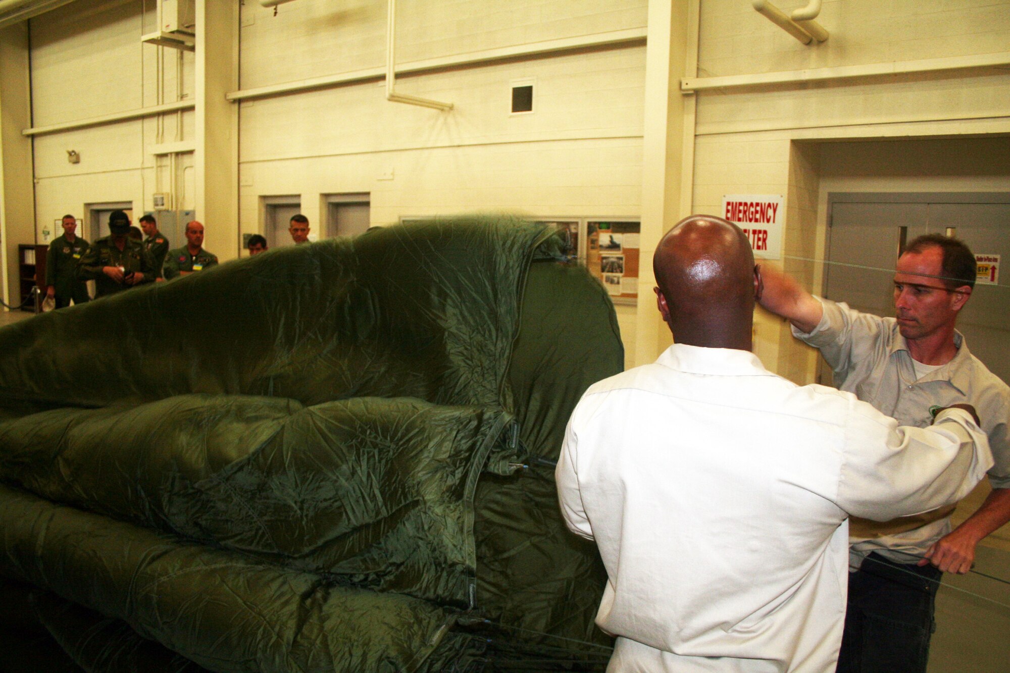 Romereo Scruggs and Jay Boison, parachute riggers at the 62nd Aerial Port Squadron aerial delivery facility, prepares a parachute for an airdrop bundle during operations at the facility July 21, 2011, at Joint Base Lewis-McChord, Wash. Scruggs and Boison, who work for contractor Trailboss, Inc., is one of eight people who operate the facility and prepare airdrop training bundles for the 62nd Airlift Wing's mission. (U.S. Air Force Photo/Master Sgt. Scott T. Sturkol)