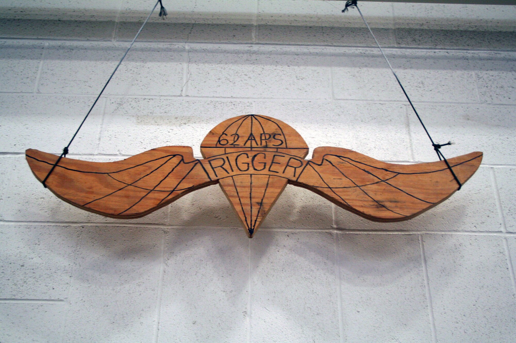 A hand-made sign depicting the parachute rigger is shown in the 62nd Aerial Port Squadron aerial delivery facility July 21, 2011, at Joint Base Lewis-McChord, Wash. Eight people operate the facility and prepare airdrop training bundles for the 62nd Airlift Wing's mission. (U.S. Air Force Photo/Master Sgt. Scott T. Sturkol)