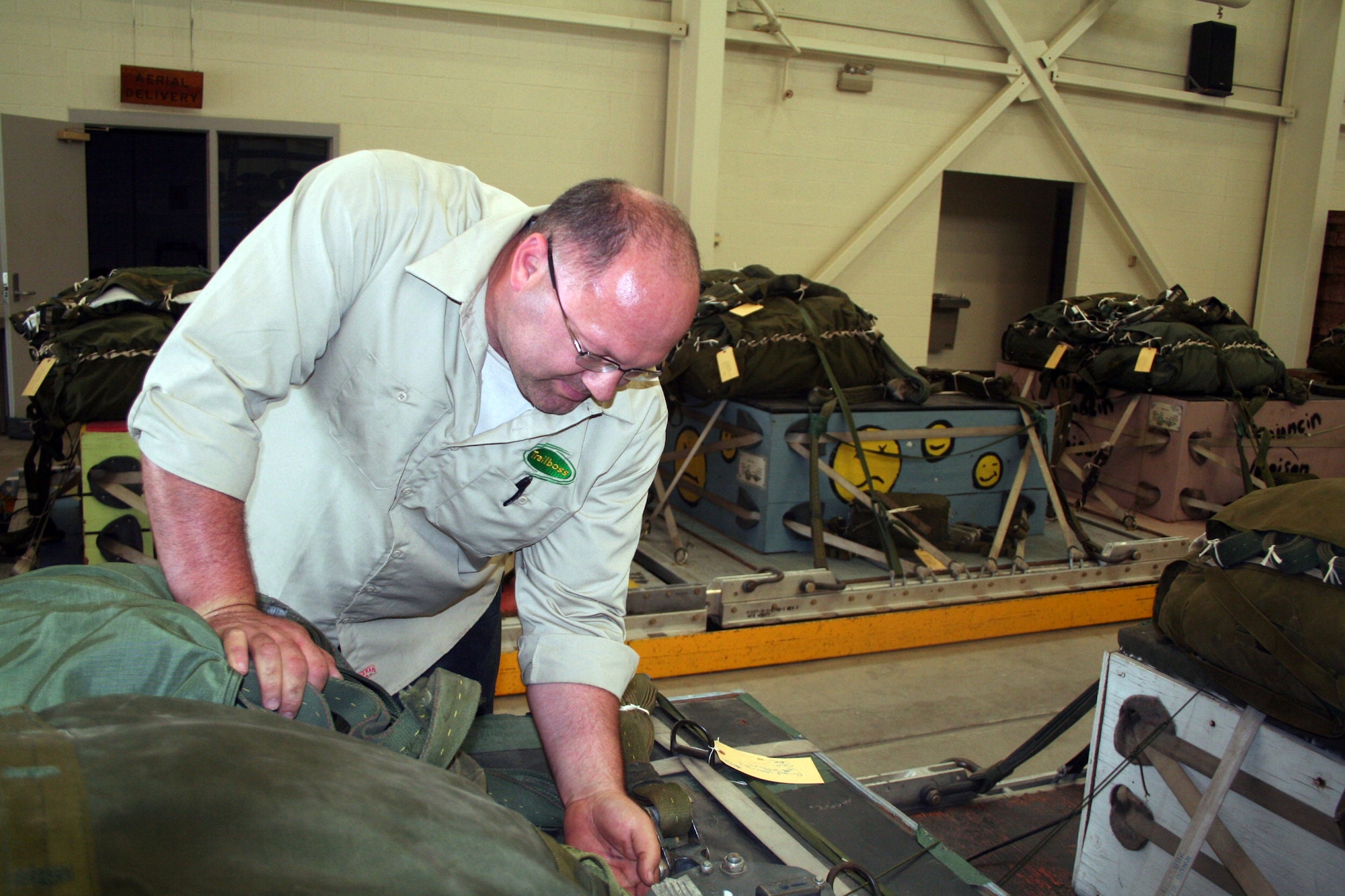 Wayne Fangman, project manager for aerial delivery at the 62nd Aerial Port Squadron aerial delivery facility, looks over an airdrop bundle during operations at the facility July 21, 2011, at Joint Base Lewis-McChord, Wash. Fangman, who works for contractor Trailboss, Inc., is one of eight people who operate the facility and prepare airdrop training bundles for the 62nd Airlift Wing's mission. (U.S. Air Force Photo/Master Sgt. Scott T. Sturkol)