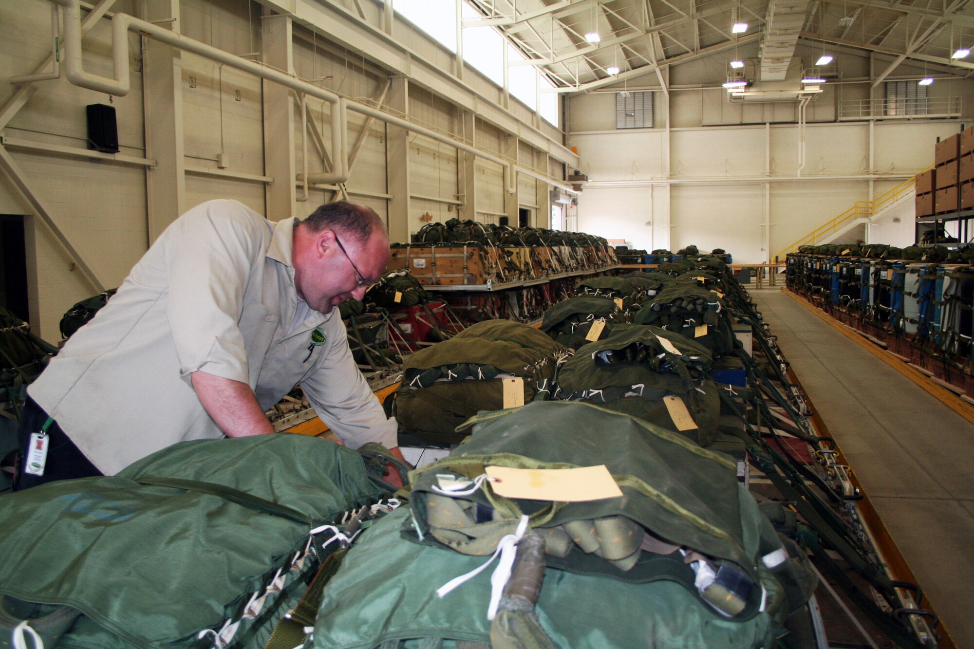 Wayne Fangman, project manager for aerial delivery at the 62nd Aerial Port Squadron aerial delivery facility, looks over an airdrop bundle during operations at the facility July 21, 2011, at Joint Base Lewis-McChord, Wash. Fangman, who works for contractor Trailboss, Inc., is one of eight people who operate the facility and prepare airdrop training bundles for the 62nd Airlift Wing's mission. (U.S. Air Force Photo/Master Sgt. Scott T. Sturkol)