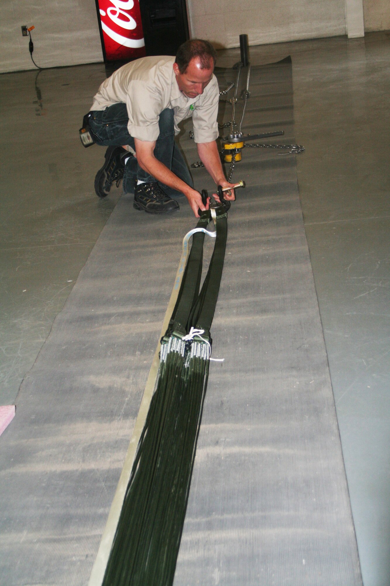 Jay Boison, parachute rigger and fabricator at the 62nd Aerial Port Squadron aerial delivery facility, prepares a parachute for an airdrop bundle during operations at the facility July 21, 2011, at Joint Base Lewis-McChord, Wash. Boison, who works for contractor Trailboss, Inc., is one of eight people who operate the facility and prepare airdrop training bundles for the 62nd Airlift Wing's mission. (U.S. Air Force Photo/Master Sgt. Scott T. Sturkol)