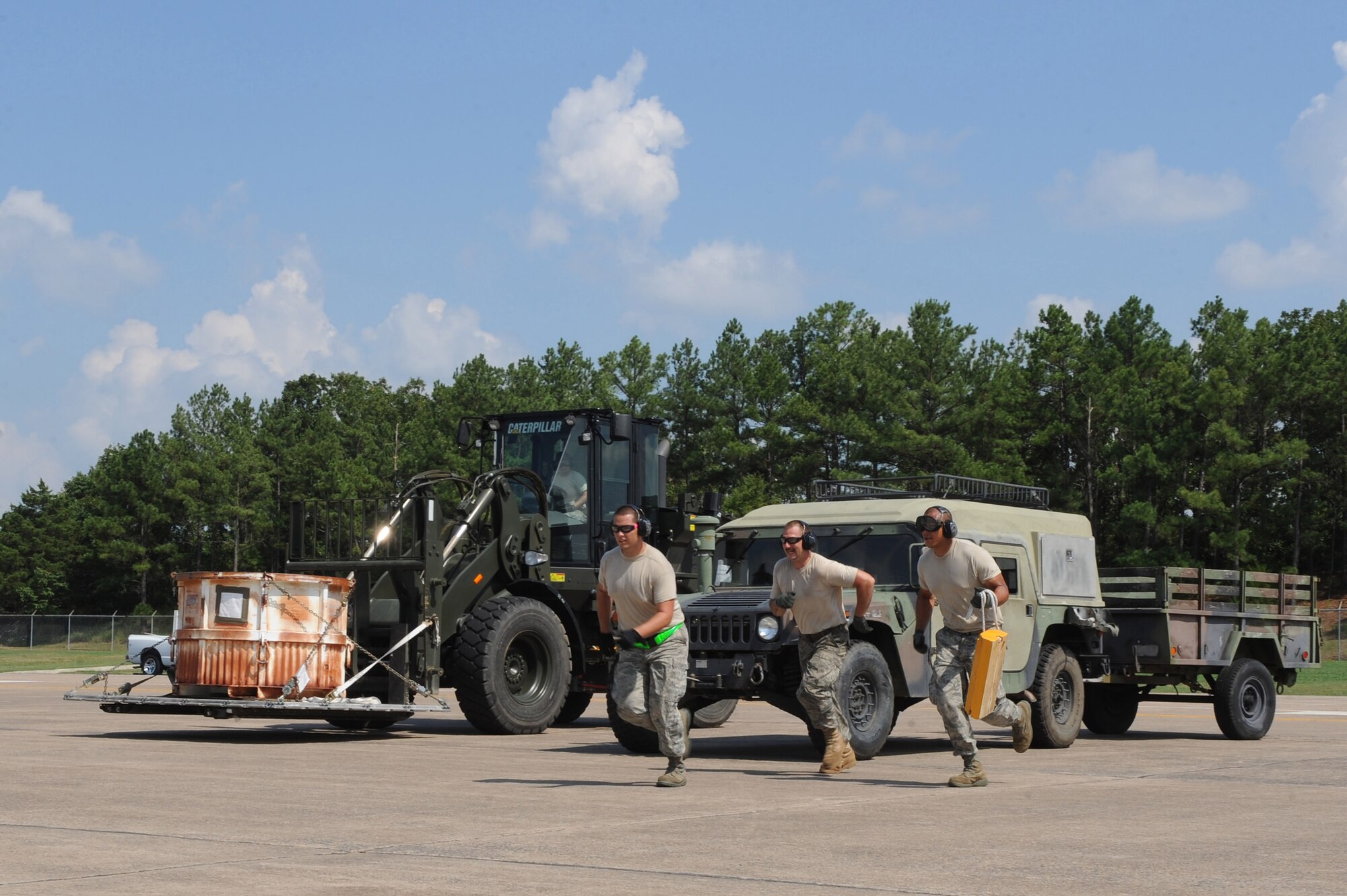 (Left to right) Senior Airman Adrian Montoya, Staff Sgt. Joseph Chilton and Senior Airman Kekoa Nelson, 19th Logistics Readiness Squadron air transportation journeymen, sprint toward a C-130H3 after receiving a signal by a loadmaster to begin the Engine Running On-Load, July 15, 2011, at Little Rock Air Force Base, Ark.  The aerial port RODEO team is currently training to compete with DOD, as well as allied nations to enhance air mobility operations and promote esprit de corps during the Air Mobility Command RODEO 2011. (U.S. Air Force photo by Tech. Sgt. Chad Chisholm)