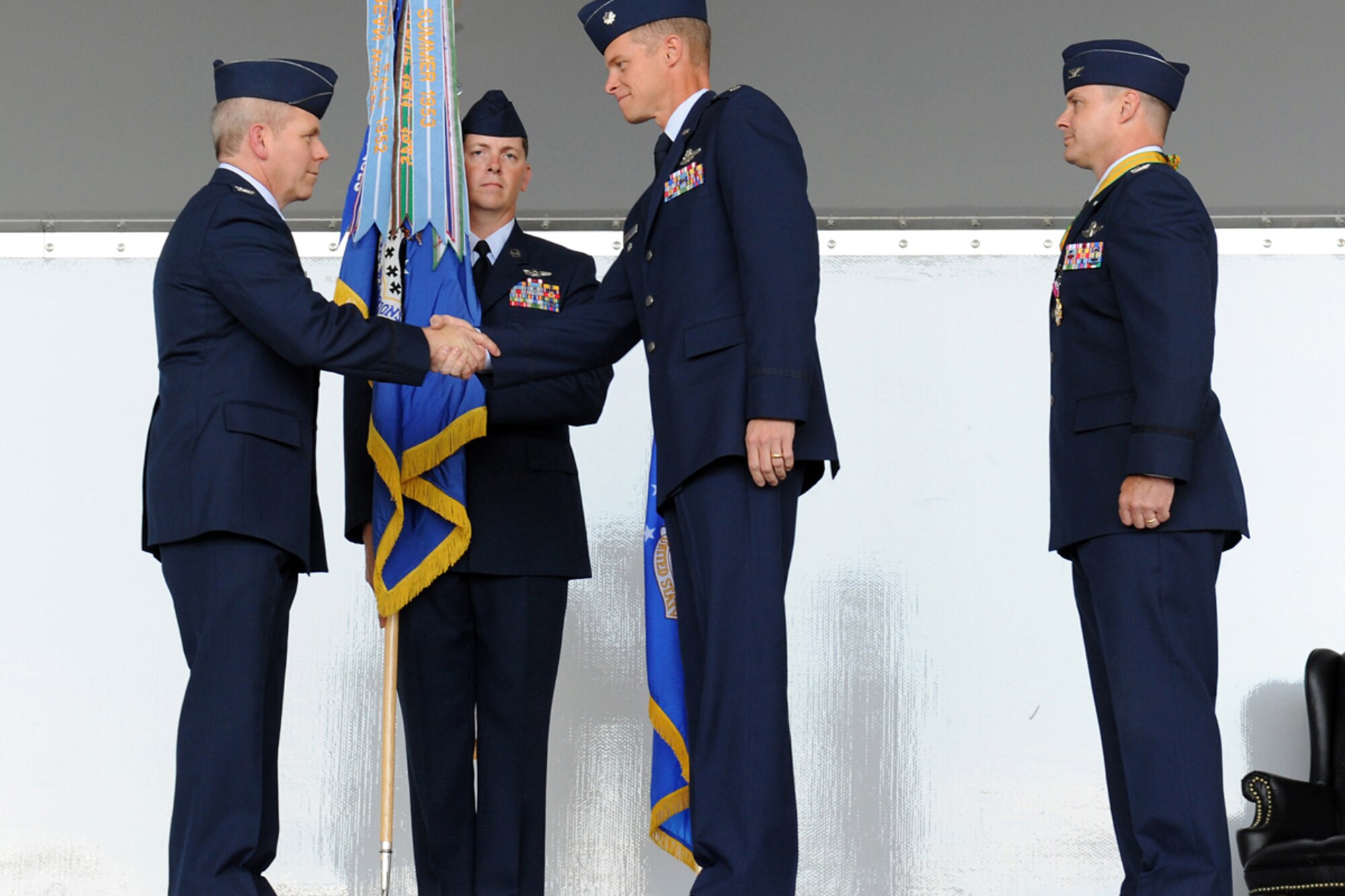 Col. John K. McMullen, left, shakes hands with 3rd Operations Group incoming commander, Lt. Col. Derek C. France, after France assumed command of 3rd OG. (U.S. Air Force photo/Justin Connaher)