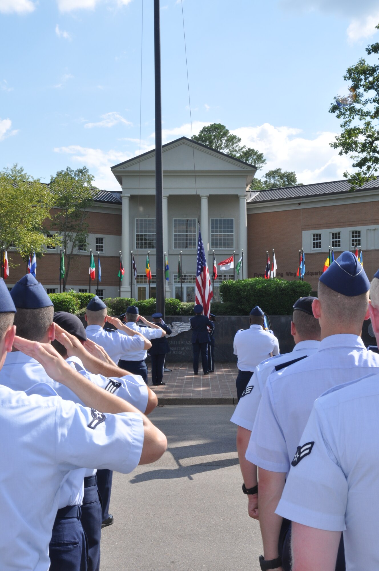 Team BLAZE Airmen salute the American flag as it is caught by base honor guard members during the Wing Retreat Ceremony on July 18 in front of the 14th Flying Training Wing headquarters. The playing of retreat traditionally signals the end of the duty day. (U.S. Air Force photo/Airman 1st Class Chase Hedrick)