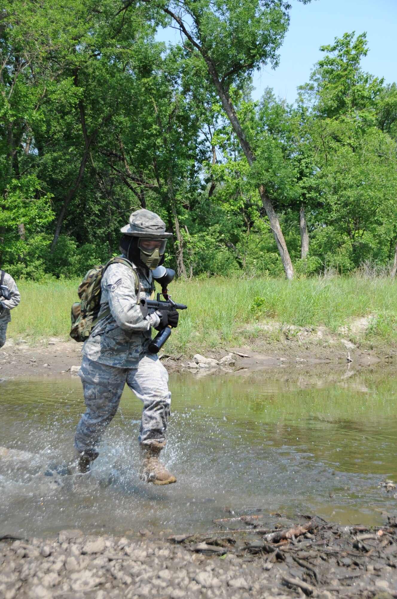 River Crossing: Senior Airman Katie Paden, a fire team member, crosses a small creek during a paintball exercise during the 155th Security Forces Squadron’s field training exercise at Camp Ashland, Neb., June 8.