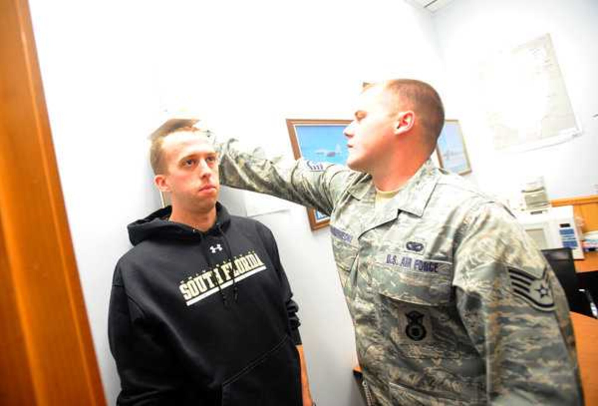 Staff Sgt. Kevin Krzemieniecki, 361st RCS, measures Cory Stites at the Air Force Recruiting Office Tuesday in Tacoma. (US Air Force photo/Ingrid Barrentine)
