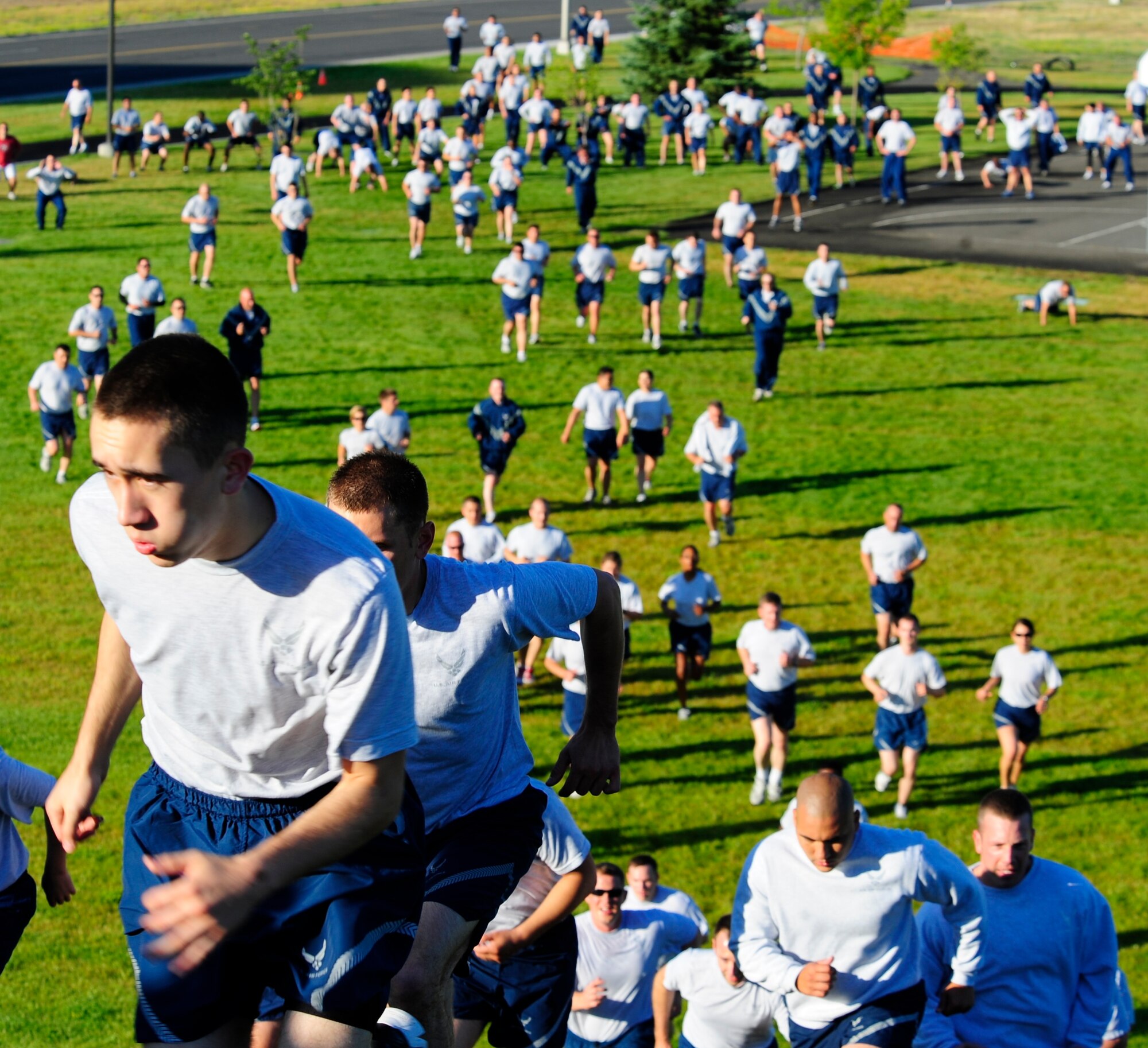 Hundreds of Airmen from the 92nd Air Refueling Wing complete the final leg of the monthly wing Fun Run July 15. July’s run was different than the previous runs by adding exercise stations throughout the course. At the base of the hill in Miller Park, runners stopped to do ten squats before before completing the final leg to the parade grounds across from the wing headquarters building. (U.S. Air Force photo/Staff Sgt. J.G. Buzanowski)