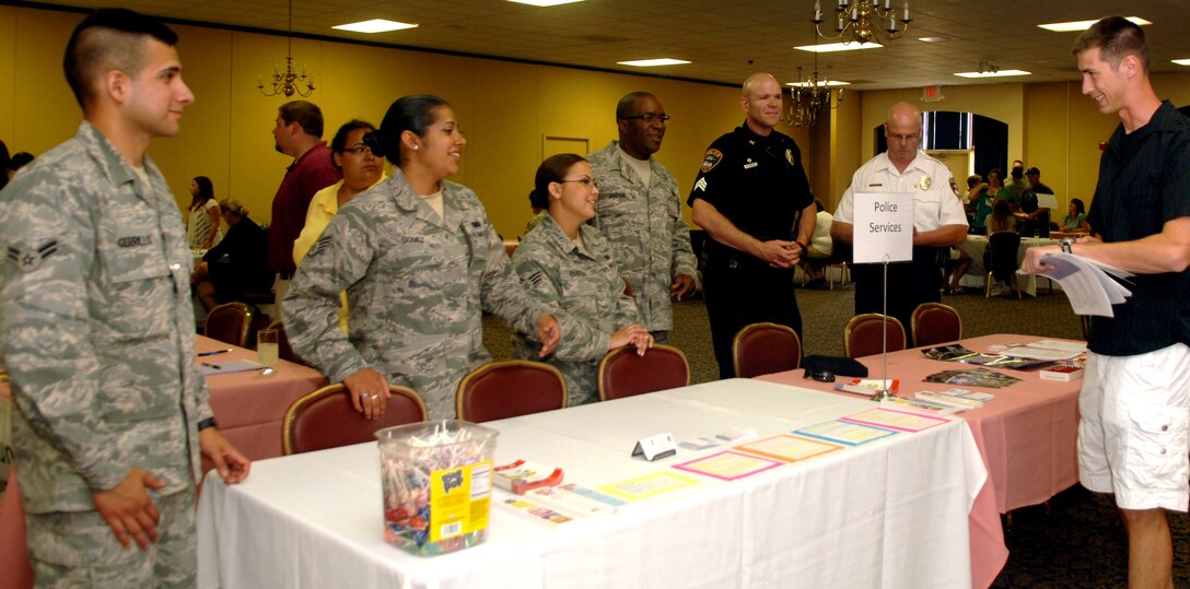 Representatives from the 28th Security Forces Squadron and area police departments wait to answer questions from a newcomer during the Happy Landings orientation at Ellsworth Air Force Base, S.D., July 19, 2011.  By providing an open forum for new arrivals and family members to meet personally with representatives from base agencies and the local community, Airmen and their families can learn about their new environment without sitting through briefing after briefing.  (U.S. Air Force photo/Airman Alessandra N. Gamboa/Released)