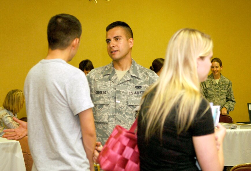 Airman 1st Class Edgar Cerrillo, 28th Security Forces Squadron patrolman, welcomes Airman 1st Class Michael Ynostroza, 28th Maintenance Squadron electrical and environmental systems apprentice,  and his wife, Katie, to the community during the Happy Landings orientation at Ellsworth Air Force Base, S.D., July 19, 2011.  Among the topics Cerrillo and other law enforcement representatives discussed were safety tips and upcoming gate closures.  (U.S. Air Force photo/Airman Alessandra N. Gamboa/Released)