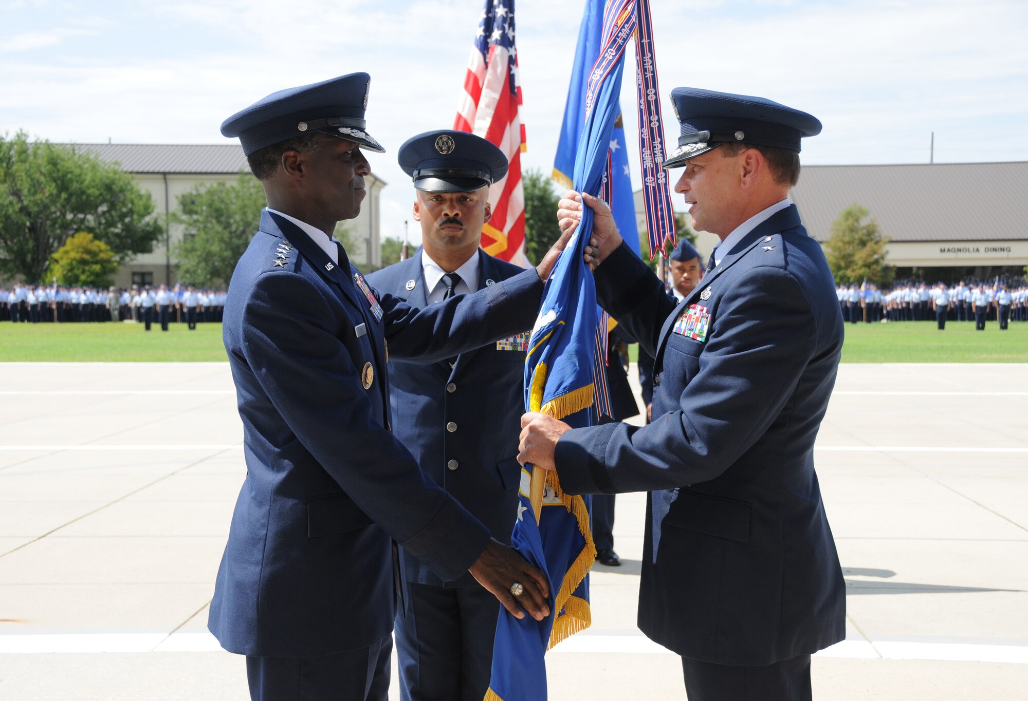 Gen. Edward Rice Jr., left, commander of Air Education and Training Command, passes the 2nd Air Force guidon to Brig. Gen. Leonard Patrick, new commander, as Chief Master Sgt. Linus Jordan, 2nd Air Force command chief, looks on during the 2nd Air Force change of command ceremony July 21 at Keesler Air Force Base, Miss.   Patrick previously commanded the 502nd Air Base Wing at Fort Sam Houston, Texas.  He replaces Maj. Gen. Mary Kay Hertog, who's headed to the Pentagon to direct the Department of Defense Sexual Assault Prevention and Response Office.  (U.S. Air Force photo by Kemberly Groue)
