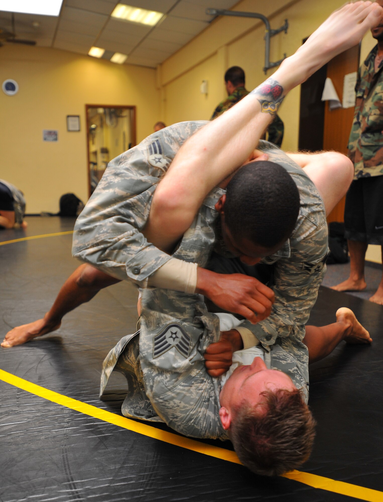 SPANGDAHLEM AIR BASE, Germany – Staff Sgt. Eric Sims, bottom, 52nd Component Maintenance Squadron, attempts to secure a triangle choke hold against Senior Airman Reginald Ward, 606th Air Control Squadron, during a combatives training class at the Skelton Memorial Fitness Center here July 19. Combatives classes last five days and are free for active-duty military and family members 18 years and older. (U.S Air Force photo/Airman 1st Class Dillon Davis)