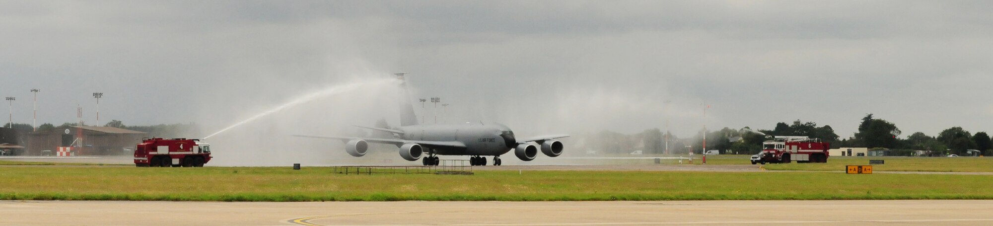 RAF MILDENHALL, England -- Col. Mike Winters, 100th Air Refueling Wing vice commander, taxis a KC-135 Stratotanker through the traditional arc of water from two base fire trucks, after his final flight here July 21, 2011. Once the aircraft was parked, he came down the ladder to the traditional welcome of a soaking from his family and an array of base leaders. (U.S. Air Force photo/Karen Abeyasekere)