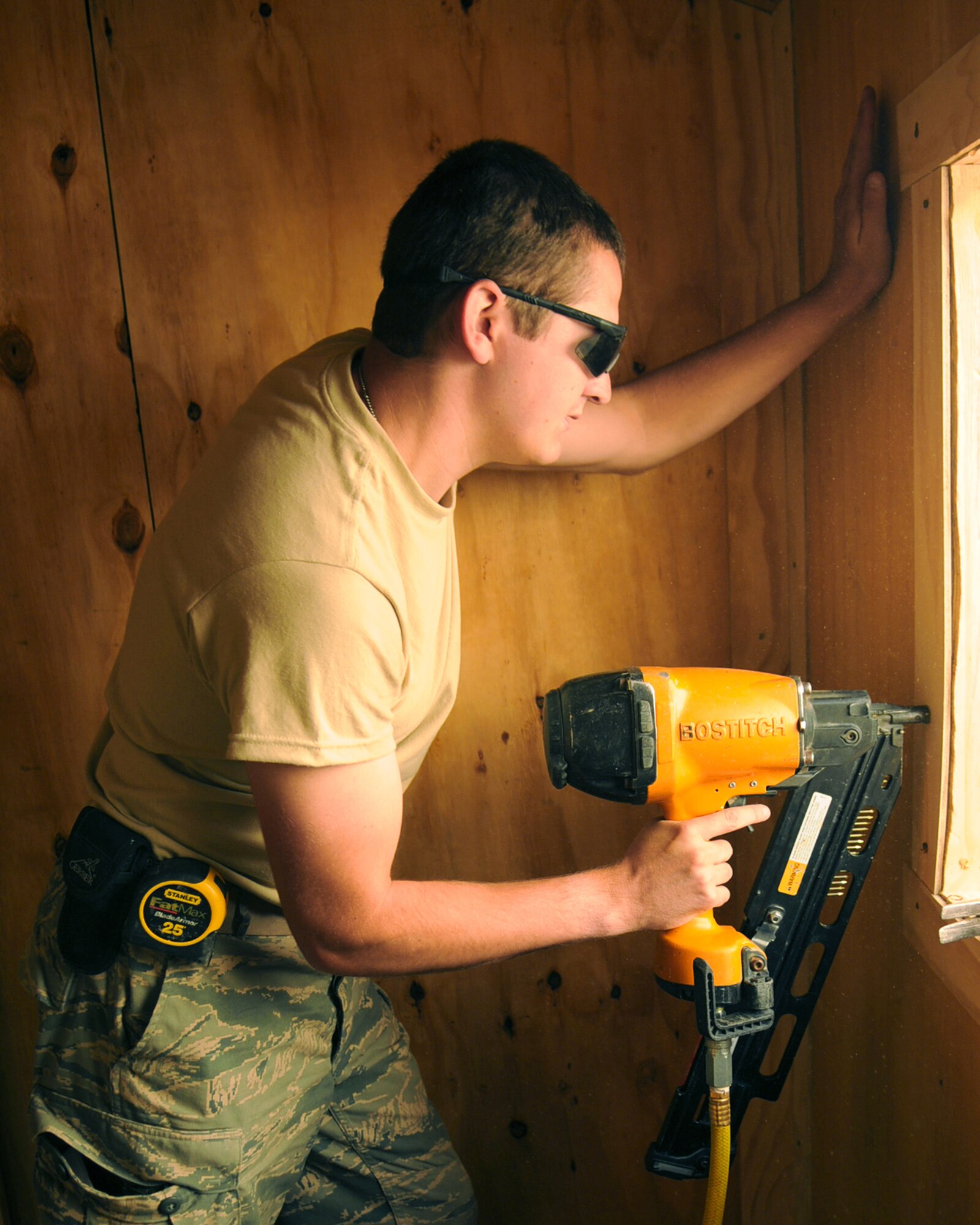 BAGRAM AIRFIELD, Afghanistan -- Staff Sgt. Mark Rollyson, 455th Expeditionary Civil Engineer Squadron structural technician, nails in the framing of a window July 21, 2011. Rollyson is working on a project to construct a new flight medicine office. Rollyson is stationed at the 121st Air Refueling Wing Air National Guard Base, Ohio.  (U.S. Air Force photo/Senior Airman Krista Rose) 