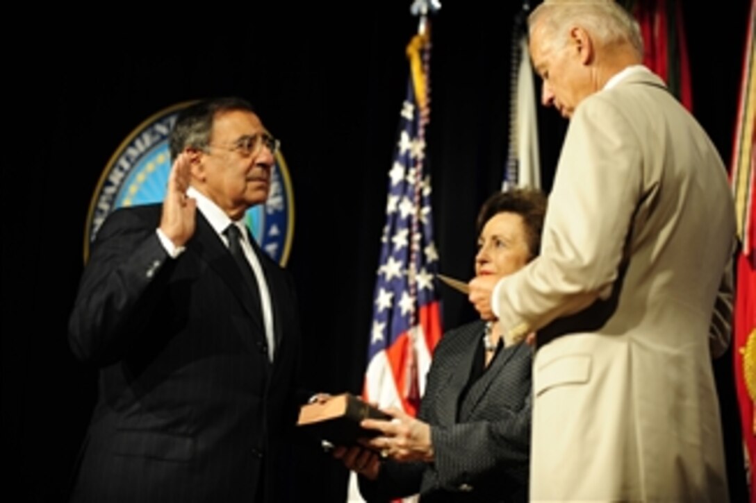 Vice President of the United States Joe Biden administers the oath of office to Secretary of Defense Leon E. Panetta, accompanied by his wife Sylvia, during a ceremony in the Pentagon on July 22, 2011.  