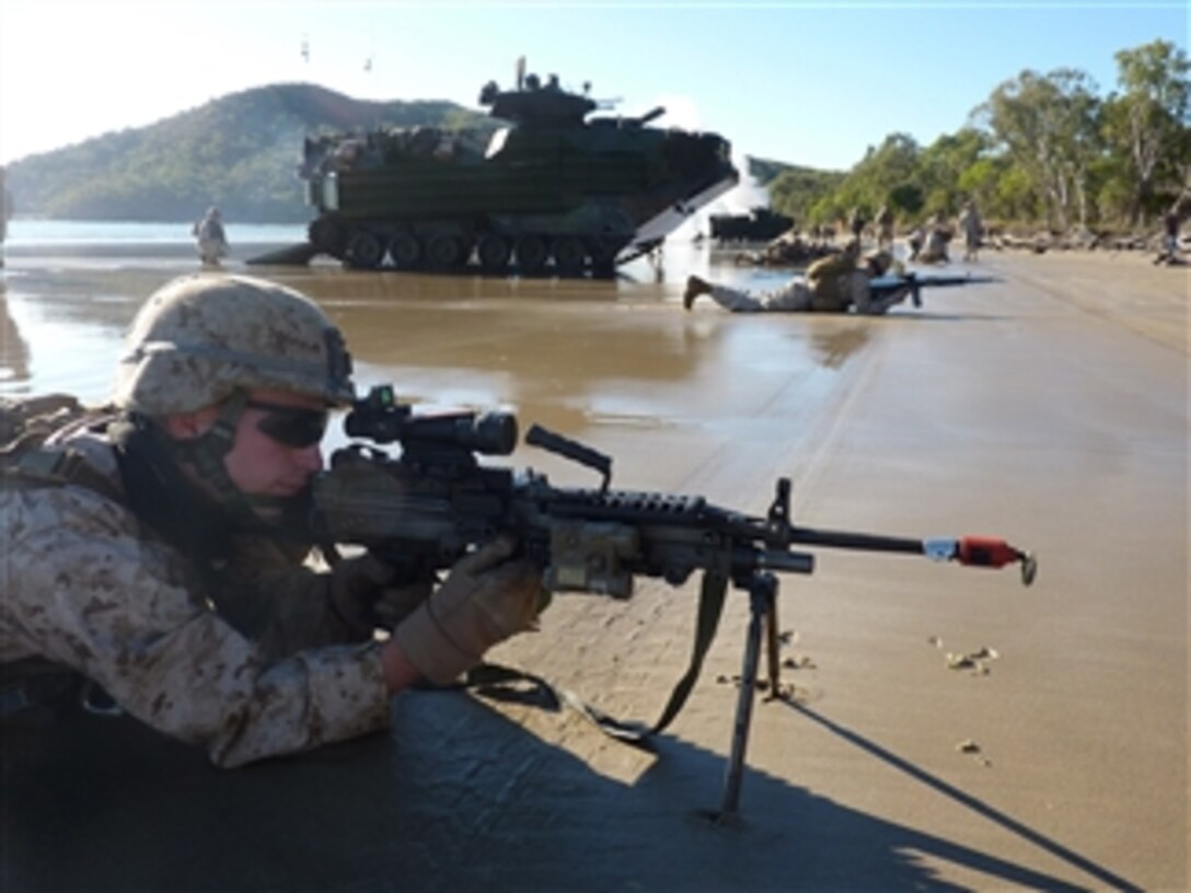 U.S. Marine Corps Lance Cpl. Jacob Cripps, with Golf Company, Battalion Landing Team, 2nd Battalion, 7th Marine Regiment, 31st Marine Expeditionary Unit, takes position with an M249 light machine gun on the beach at Shoalwater Bay Training Area in Queensland, Australia, during an amphibious landing for Talisman Sabre 2011 on July 19, 2011.  Talisman Sabre is a combined biennial exercise between the U.S. and Australian militaries designed to enhance both nations? ability to respond to regional contingencies.  
