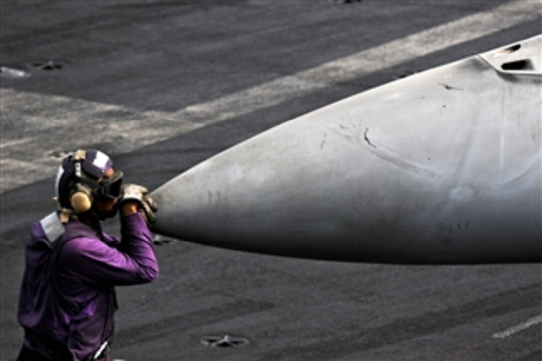 U.S. Navy Petty Officer 3rd Class Bryan Herring takes a moment to relax on the flight deck aboard the aircraft carrier USS George H.W. Bush in the Arabian Sea on July 19, 2011.  The George H.W. Bush is deployed supporting maritime security operations and theater security cooperation efforts in the U.S. 5th Fleet area of responsibility on its first operational deployment.  Herring is an aviation boatswain's mate.  