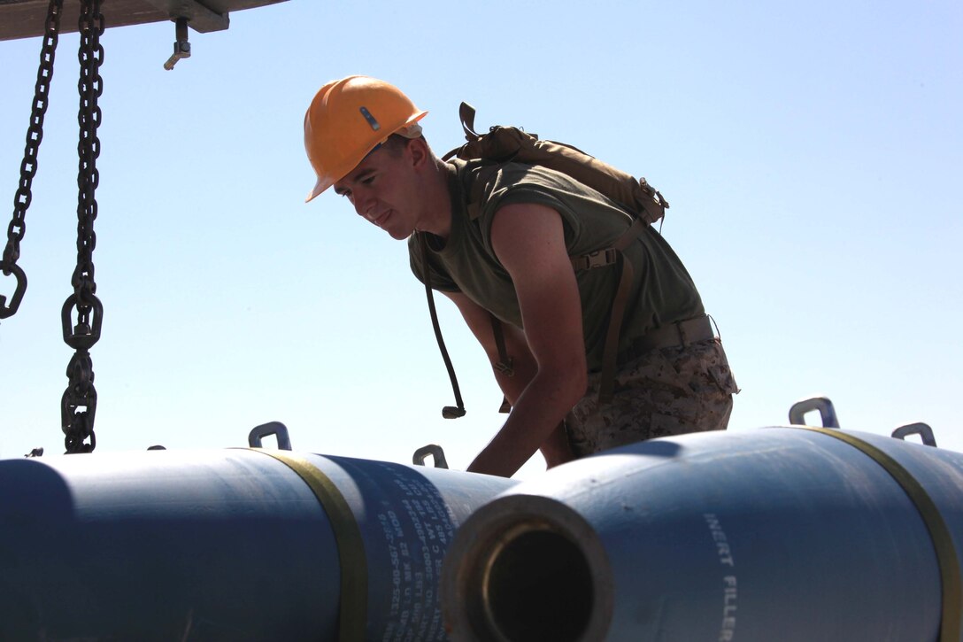 Pfc. Jason W. Gaglione, II, Marine Aircraft Group 41 aviation ordnance system technician, secures 500-pound bombs to a trailer before transportation to the hanger for Operation Javelin Thrust at Marine Corps Air Station Yuma, Ariz., July 22. The ordnance Marines build and transport the bombs based on the needs of the air component.