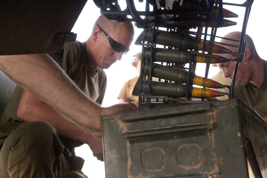 Sgt. Toby Galbraith, left, a Missoula, Mo., native, and Lance Cpl. Seth Barnes, a Circleville, Ohio, native, both Marine Attack Squadron 513 ordnance technicians, download rounds off one of the squadron’s AV-8B Harriers on the flightline of Kandahar Airfield, Afghanistan, July 23.