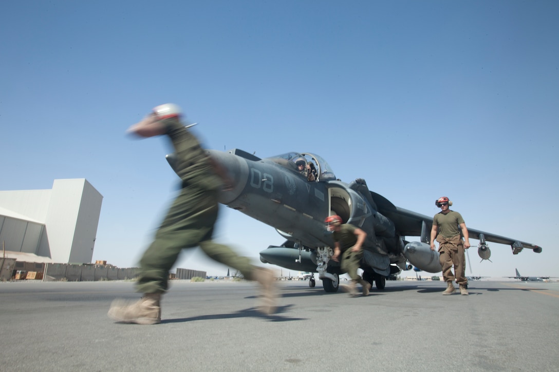 Cpl. Timothy Johnson, left, Lance Cpl. Seth Barnes and Cpl. Reid Dawson, all Marine Attack Squadron 513 ordnance technicians, disarm one of the squadron’s AV-8B Harriers after a flight on the flightline of Kandahar Airfield, Afghanistan, July 23.