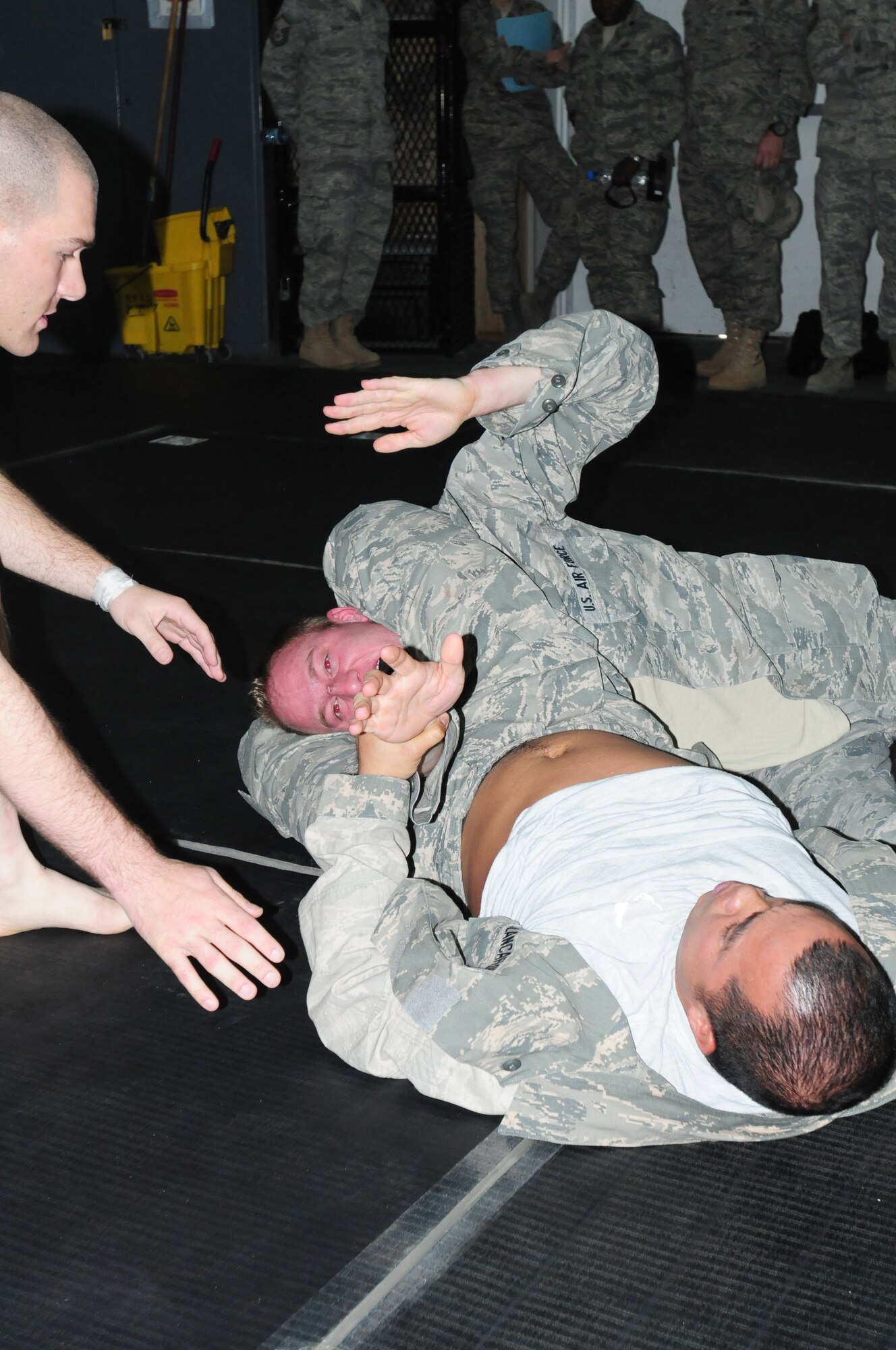 Staff Sgt. Manasseh Blancaflor submits his oponent using a triangle choke. Blancaflor was named honor graduate of a weeklong Modern Army Combatives Program course at the 380th Air Expeditionary Wing in Southwest Asia, July 22, 2011. The course gave a  group of deployed Airmen and Soldiers  the opportunity to learn basic ground technique and how to maintain a dominant position, establish simple submissions, gain a clinch and subdue a striking opponent. Blancaflor works in the special events section of the 380th Expeditionary Force Support Squadron and is deployed from Hickam Air Force Base, Hawaii. (U.S. Air Force photo/1st Lt. Gina McKeen)