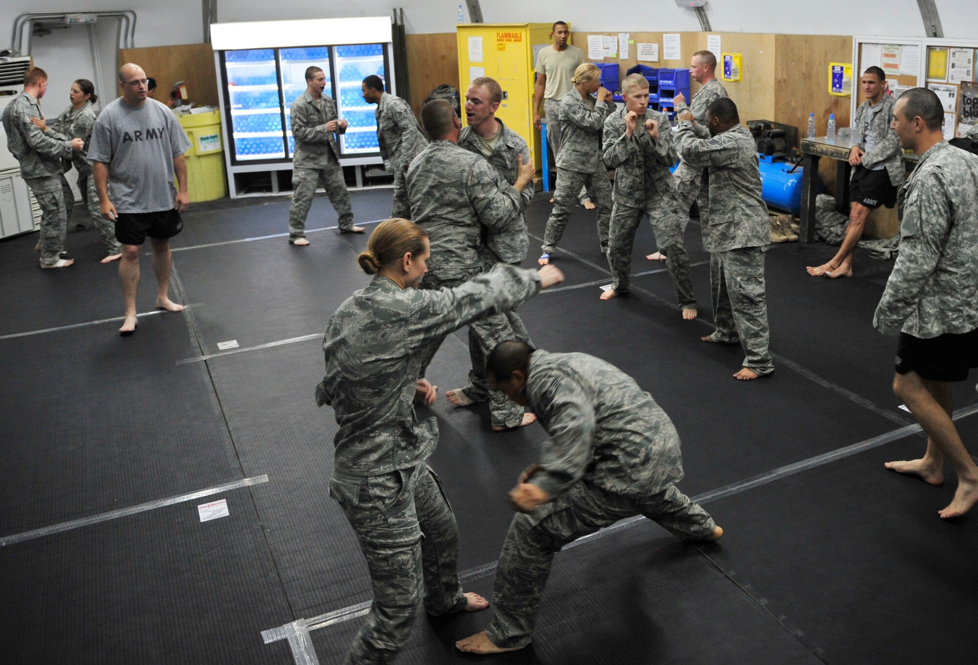 A group of deployed Airmen and Soldiers gain valuable training during a weeklong Modern Army Combatives Program course at the 380th Air Expeditionary Wing in Southwest Asia, July 2011. The course gave a  group of deployed Airmen and Soldiers  the opportunity to learn basic ground technique and how to maintain a dominant position, establish simple submissions, gain a clinch and subdue a striking opponent.  (U.S. Air Force photo/Staff Sgt. Patrick Mitchell)