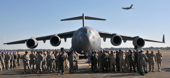 Mobility Airmen standby for the official kick off of Air Mobility Rodeo 2011, July 24, 2011, standing in front of a C-17 Globemaster III at Joint Base Lewis-McChord, Wash. Air Mobility Rodeo 2011 is a biennial international competition that focuses on mission readiness, featuring airdrops, aerial refueling and other events that showcase the skills of mobility crews from around the world. On the right is a formation of airmen from Pakistan, one of seven international teams competing. (U.S. Air Force photo/ Airman 1st Class Jared Trimarchi) 