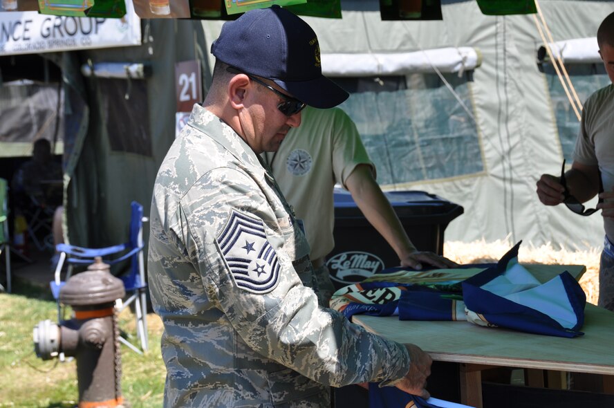Chief Master Sgt. John Evalle, 60th Air Mobility Wing command chief, sets up banners July 24, 2011 at the Team Travis Air Mobility Rodeo 2011 hospitality tent. Air Mobility Rodeo 2011 is a biennial international competition that focuses on mission readiness, featuring airdrops, aerial refueling and other events that showcase the skills of mobility crews from around the world.(U.S. Air Force photo/Airman 1st Class Michael Battles)