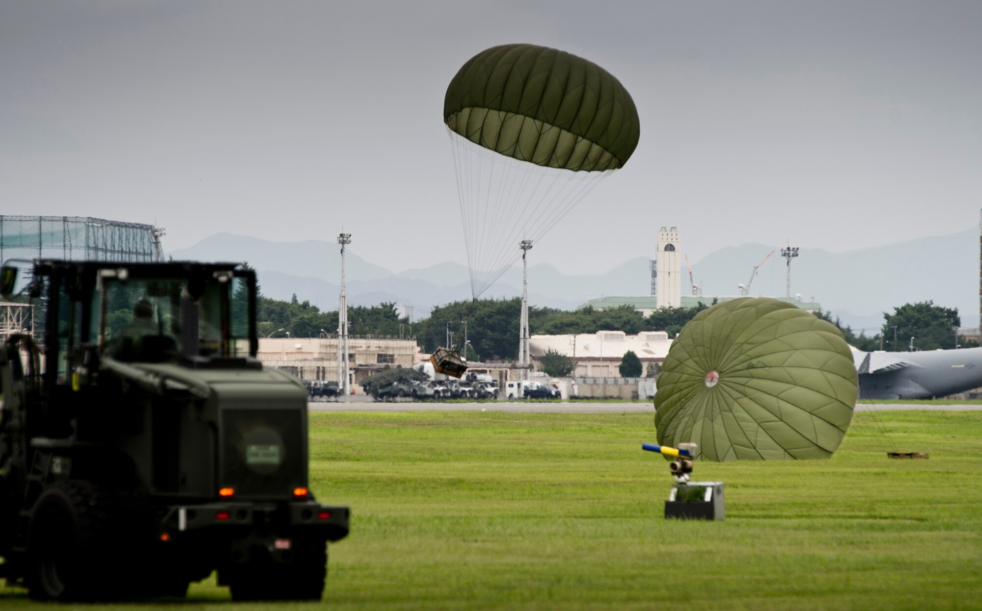 YOKOTA AIR BASE, Japan -- A simulated heavy equipment load lands at Yokota Air Base, Japan, during a practice airdrop mission July 22, 2011. Lt. Gen. Burton Field, U.S. Forces, Japan, and 5th Air Force commander, flew on the aircraft to learn more about the C-130 Hercules mission. (U.S. Air Force photo/Staff Sgt. Samuel Morse)