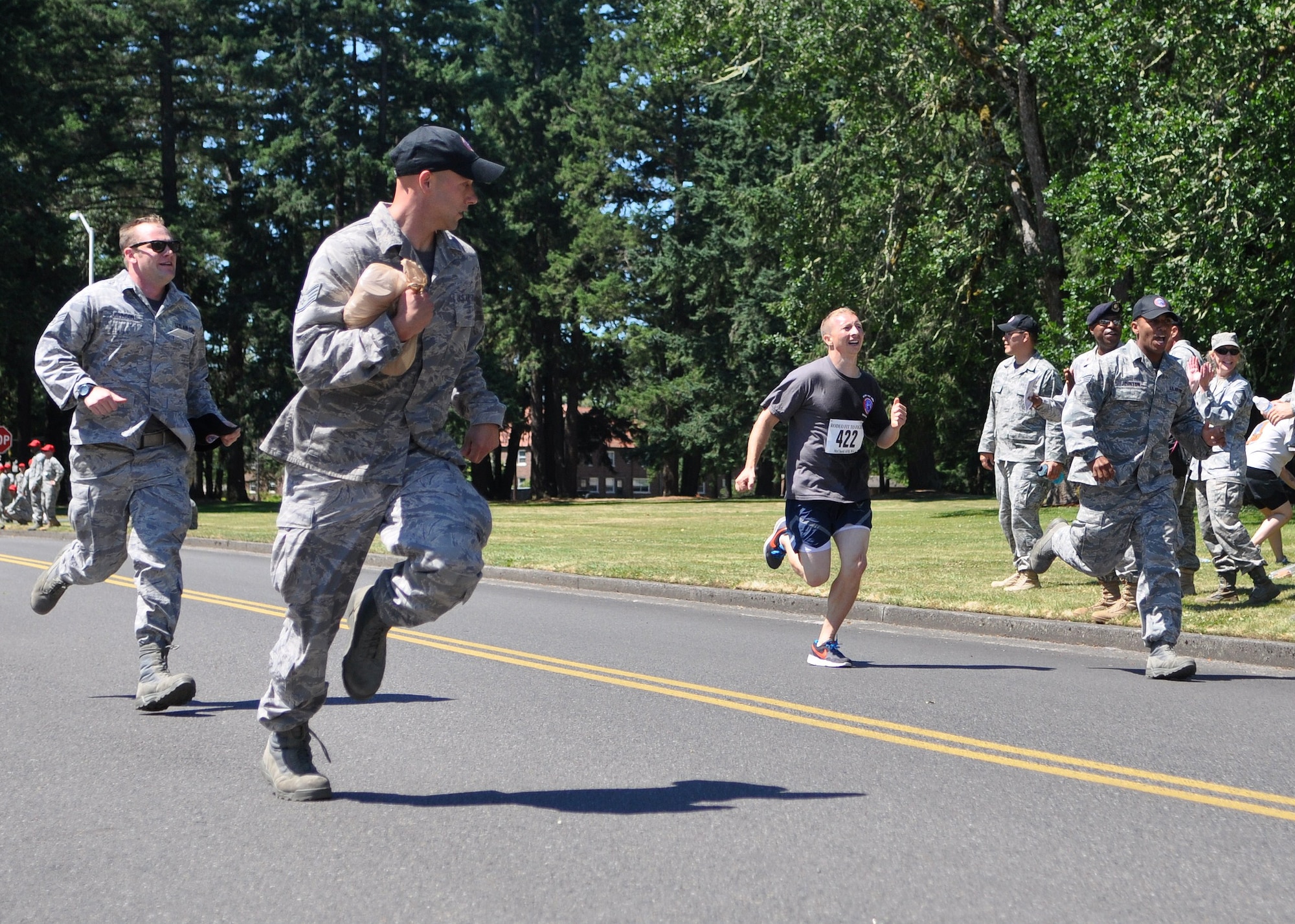 Airmen from the 62nd Aerial Port Rodeo team run with fellow Rodeo team member, Staff Sgt. Mark Robertson, center, during the last of the 1.5 mile run portion of the ‘Fit to Fight’ challenge July 24, 2011, at Joint Base Lewis-McChord, Wash. The physical challenge is just one aspect of Air Mobility Rodeo 2011, a biennial international competition that focuses on mission readiness, featuring airdrops, aerial refueling and other events that showcase the skills of mobility crews from around the world. (U.S. Air Force photo/Airman 1st Class Leah Young)