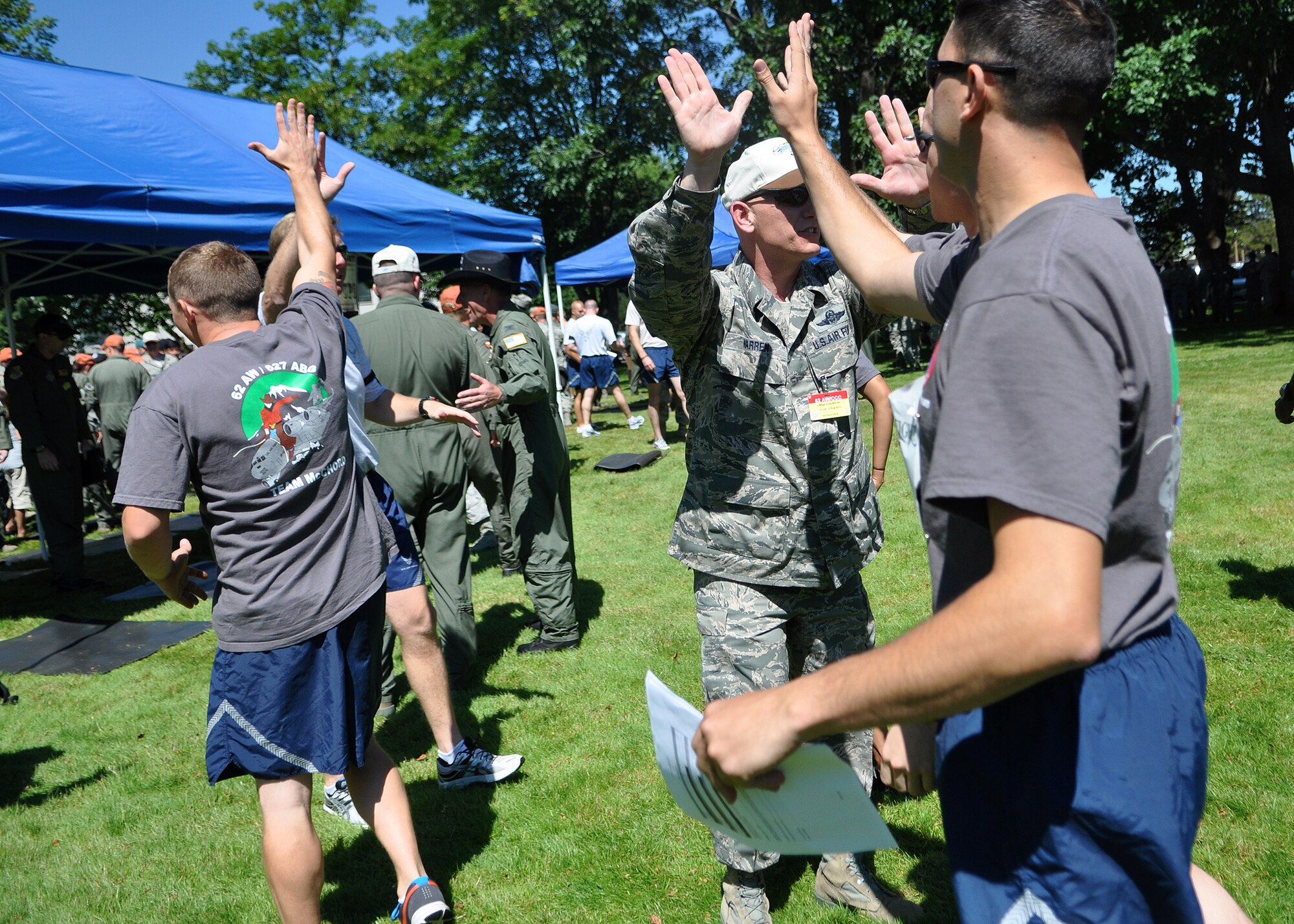 62nd Airlift Wing leadership gives high-fives to Airmen representing the 62nd Airlift Wing and 627th Air Base Group Rodeo team before the ‘Fit to Fight’ challenge July 24, 2011, at Joint Base Lewis-McChord, Wash. The challenge consisted of a 1.5 mile run and one minute of both push-ups and sit-ups. The physical challenge is just one aspect of Air Mobility Rodeo 2011, a biennial international competition that focuses on mission readiness, featuring airdrops, aerial refueling and other events that showcase the skills of mobility crews from around the world. (U.S. Air Force photo/Airman 1st Class Leah Young)