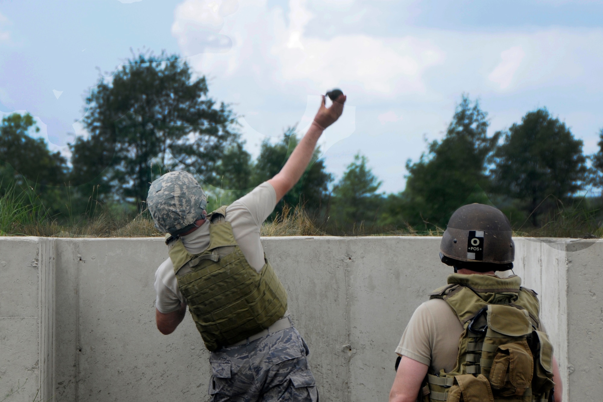 Master Sgt. Craig Cross from Selfridge Air National Guard Base, 127th Operational Support Flight, releases an M67 grenade at Camp Grayling Maneuver Training Center, Mich., during the annual Gray Wolverine training exercise, July 23, 2011. Cross came to support the 107th Weather Flight on their Gray Wolverine training as an instructor of Meteorological Weather Forecasting.  (U.S. Air Force photo by TSgt David Kujawa)