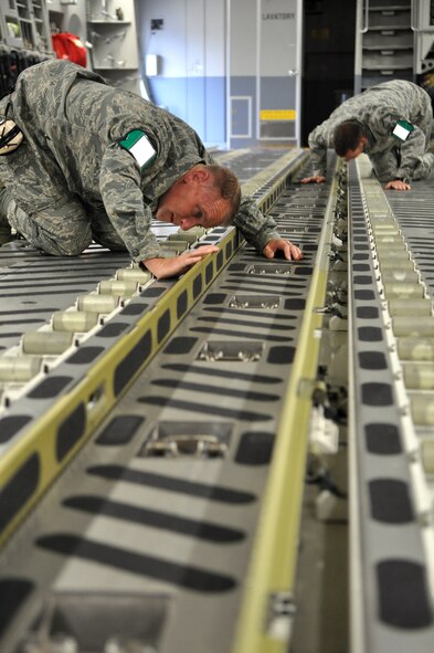 Master Sgt. Seanjon Judkins, left 62nd Maintenance Rodeo Team chief, and Master Sgt. Patrick Remfrey, 62nd Maintenance Rodeo Team member, perform a foreign object inspection while participating in a Rodeo training exercise July 21, 2011, at Joint Base Lewis-McChord, Wash. Air Mobility Rodeo 2011, sponsored by the Air Mobility Command, is the Mobility Air Force's premier readiness competition. This competition focuses on improving our worldwide air mobility forces' professional core abilities. (U.S. Air Force Photo/Airman 1st Class Leah Young) 