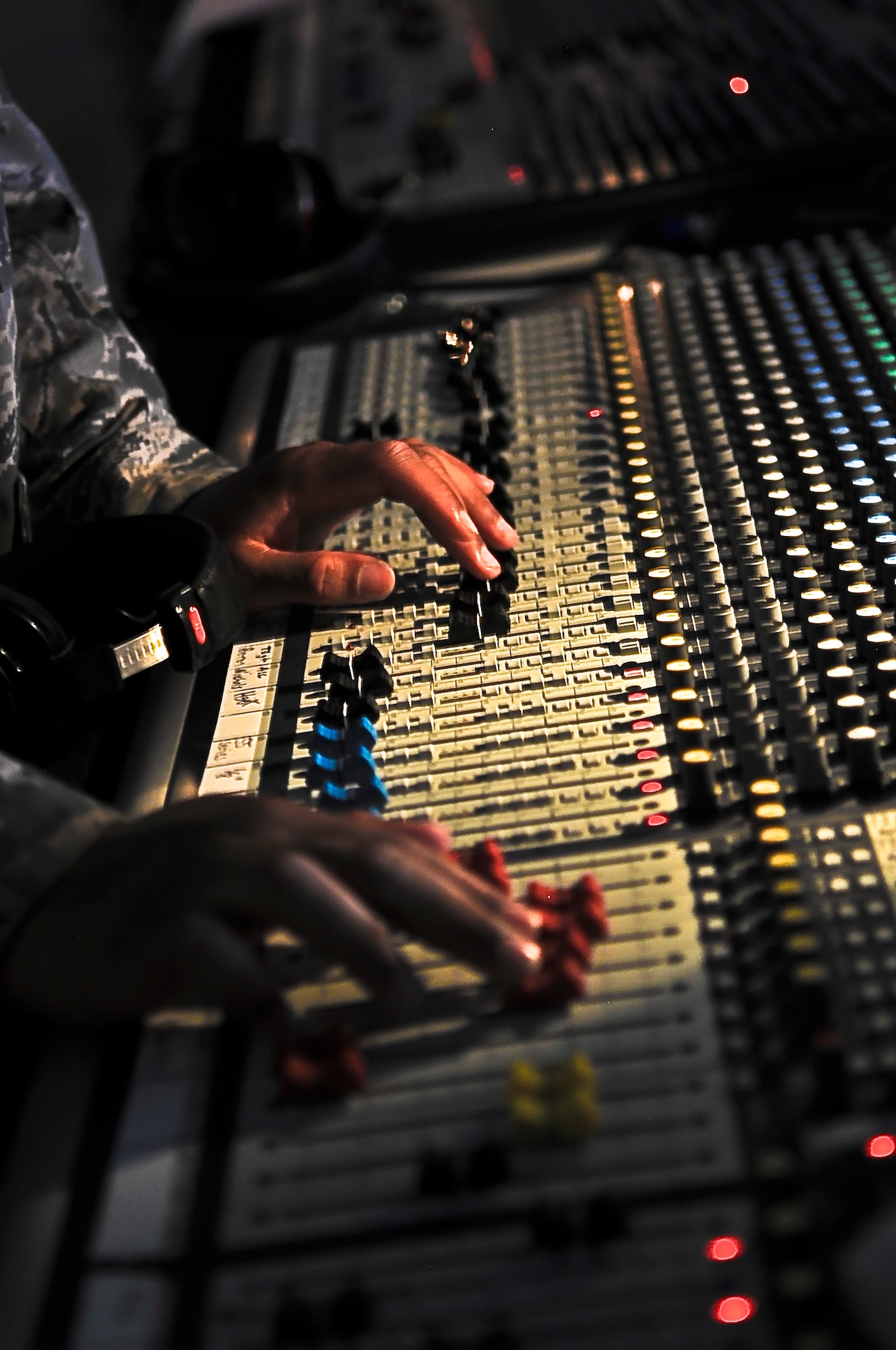 Airman 1st Class Michael Williams adjusts a soundboard during a Tops in Blue performance in Southwest Asia, July 22. With five technical personnel, the team is responsible for setting up more than 60,000 pounds of staging, lighting, audio and special effects equipment before each performance. (U.S. Air Force photo/Senior Airman Paul Labbe)