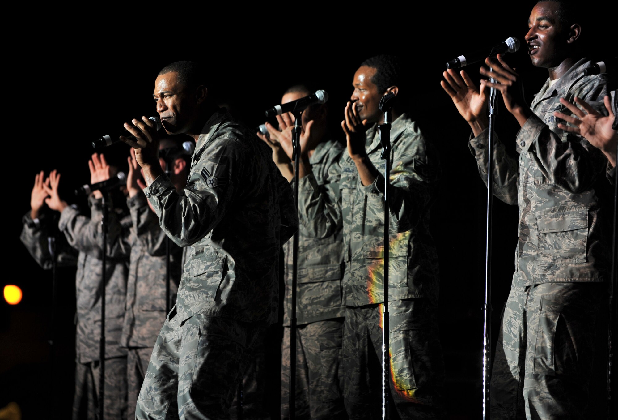 Airman 1st Class Jarod Burton, Tops in Blue vocalist, sings with his fellow Tops in Blue members during a performance in Southwest Asia, July 22. This year’s “Rhythm Nation” tour featured songs from musical artists such as Marvin Gaye, Tammi Terrell, Jenifer Lopez and many more. (U.S. Air Force photo/Senior Airman Paul Labbe)