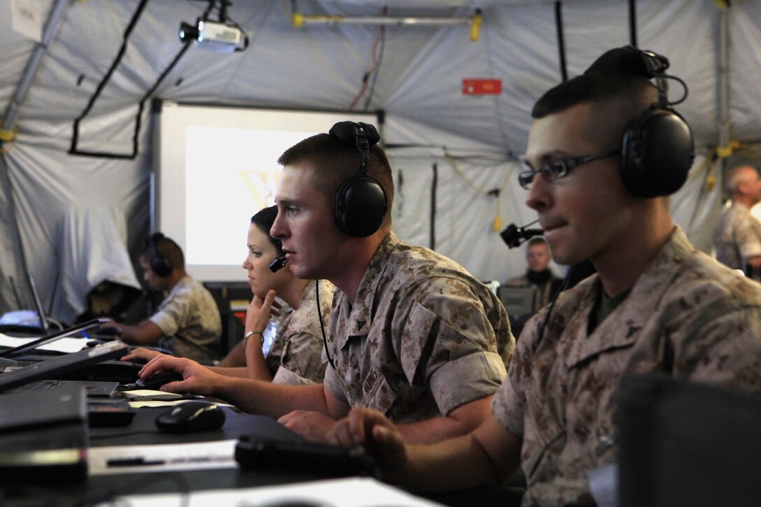 Marine tactical air command squadron 48 Marines receive aircraft and ground troop information on their monitors during Operation Javelin Thrust at Marine Corps Air Station Yuma, Ariz., July 24. The information received is then passed on to the various combat elements in the training exercise to keep them informed on current operations.