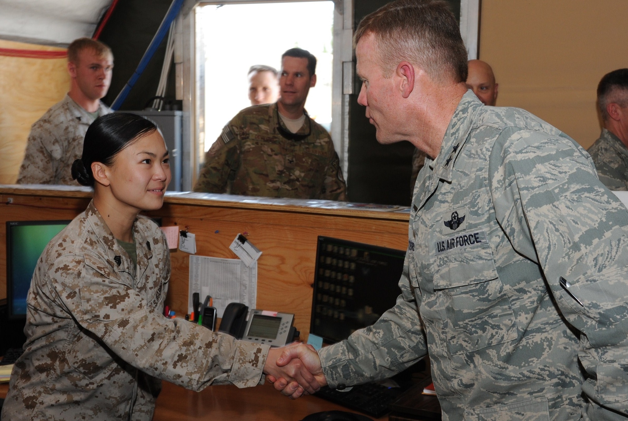 Maj. Gen. Tod Wolters introduces himself to Marine Sgt. Felisia Kusuma during a tour of the Joint Movement Control Center at the Transit Center at Manas, Kyrgyzstan, July 24. Kusuma is a Marine liaison officer deployed here from Marine Light Attack Helicopter Squadron 269 at Camp Lejuene, N.C. Wolters is the commander of the 9th Air and Space Expeditionary Task Force - Afghanistan and deputy commander for air at U.S. Forces-Afghanistan. (U.S. Air Force photo/Tech. Sgt. Hank Hoegen)