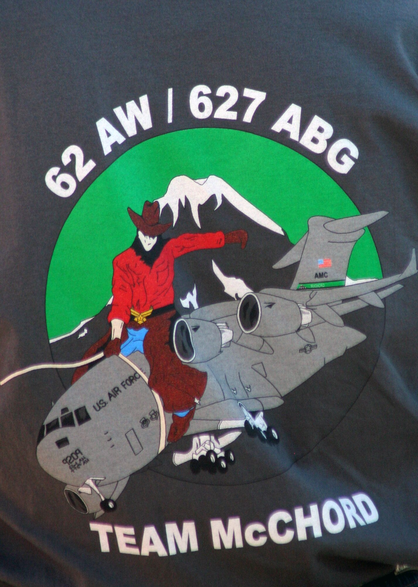 A T-shirt with the logo for the Air Mobility Rodeo 2011 team for McChord Field is shown on a spectator for opening ceremonies for Rodeo on July 24, 2011, at Joint Base Lewis-McChord, Wash.  Rodeo 2011, sponsored by the Air Mobility Command, is the Mobility Air Force's readiness competition. This competition focuses on improving worldwide air mobility forces' professional core abilities. More than 150 teams and 3,000 people from the Air Force, and Air Force Reserve, as well as allied nations are participating in Rodeo. (U.S. Air Force Photo/Master Sgt. Scott T. Sturkol)