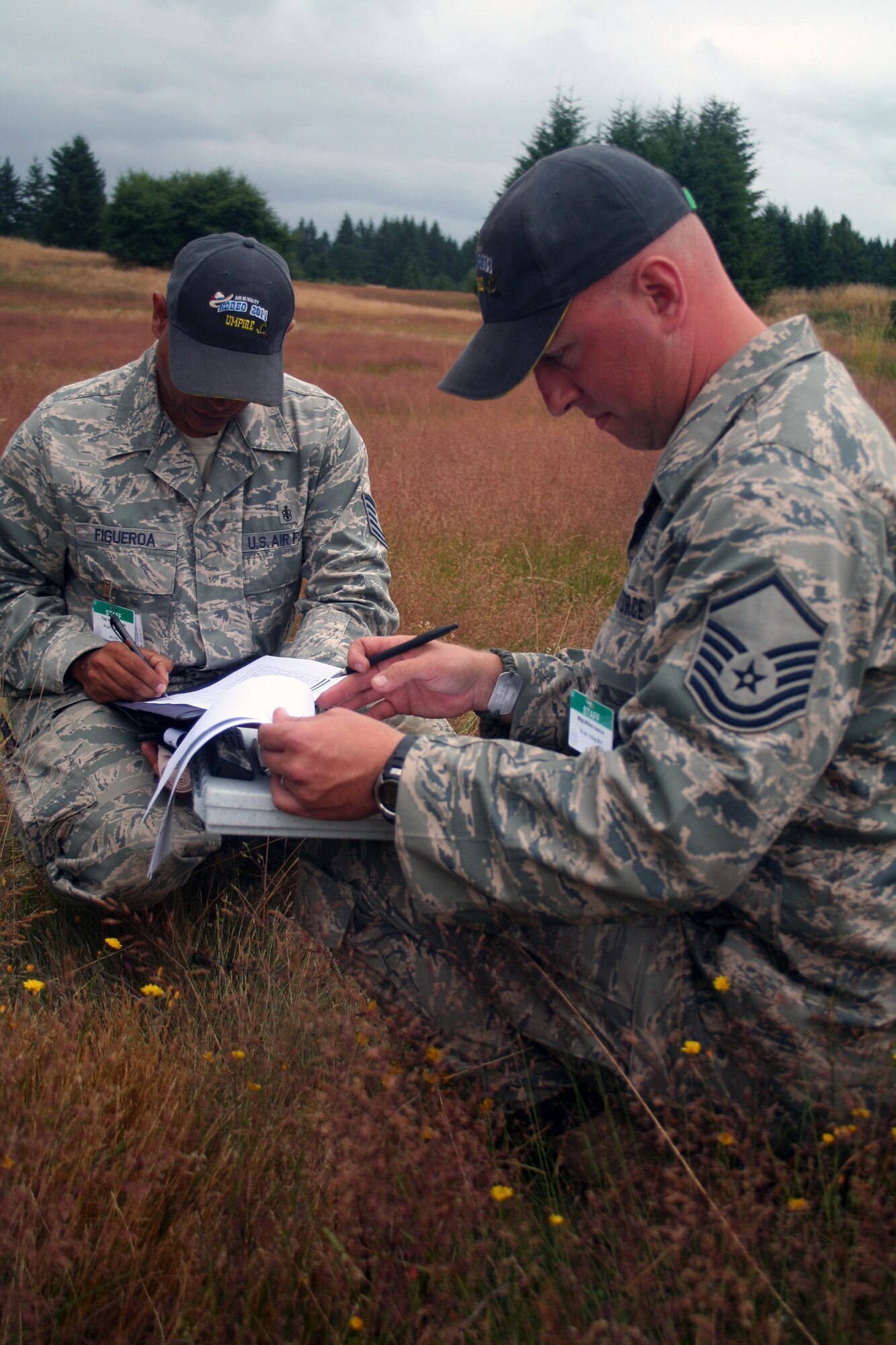 Tech. Sgt. Victor Figueroa and Master Sgt. Bill Gaskins, Air Mobility Rodeo 2011 umpires from the 421st Combat Training Squadron at the U.S. Air Force Expeditionary Center on Joint Base McGuire-Dix-Lakehurst, N.J., review checklists for the Rodeo security forces combat tactics event at Joint Base Lewis-McChord, Wash., on July 25, 2011. (U.S. Air Force Photo/Master Sgt. Scott T. Sturkol)