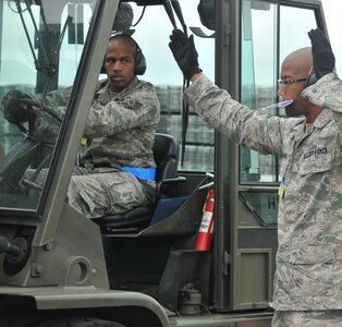 Two Airmen work together to complete a forklift driving course, July 25, 2011 at Joint Base Lewis-McChord. The event was part of Air Mobility Rodeo 2011, a biennial international competition that focuses on mission readiness, featuring airdrops, aerial refueling and other events that showcase the skills of mobility crews from around the world. (U.S. Air Force photo/ Airman 1st Class Jared Trimarchi) 