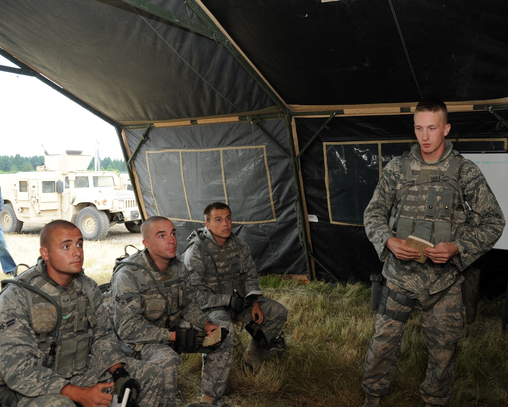 JOINT BASE LEWIS-MCCHORD, Wash. – (L to R) Airmen 1st Class Joshua Sams, Scott Stickney, Eric Newland and Staff Sgt. Stephen Hebblethwaite, 97th Security Forces Squadron, Altus Air Force Base, Okla. Rodeo Team discus their plan before competing in the Combat Tactics course during the 2011 Air Mobility Command Rodeo July 25. During the Combat Tactics competition, four-person teams were tested in combat-critical areas that demonstrate each team's ability to shoot, move and communicate. (U.S. Air Force photo by Airman 1st Class Kenneth W. Norman / Released / 97th Air Mobility Wing Rodeo Public Affairs)