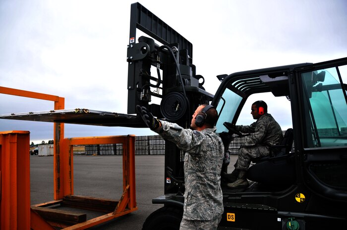 Two Airmen unload a pallet into a pallet stacker during a forklift driving course, July 25, 2011, at Joint Base Lewis-McChord, Wash. The event was part of Air Mobility Rodeo 2011, a biennial international competition that focuses on mission readiness, featuring airdrops, aerial refueling and other events that showcase the skills of mobility crews from around the world. (U.S. Air Force photo/ Airman 1st Class Jared Trimarchi) 

