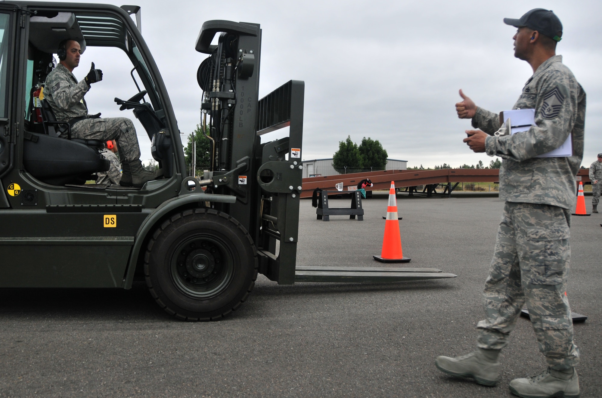 An Airman signals ?all clear? to an umpire during a forklift driving course, July, 25, 2011, at Joint Base Lewis-McChord, Wash. The event was part of Air Mobility Rodeo 2011, a biennial international competition that focuses on mission readiness, featuring airdrops, aerial refueling and other events that showcase the skills of mobility crews from around the world.  (U.S. Air Force photo/ Airman 1st Class Jared Trimarchi) 

